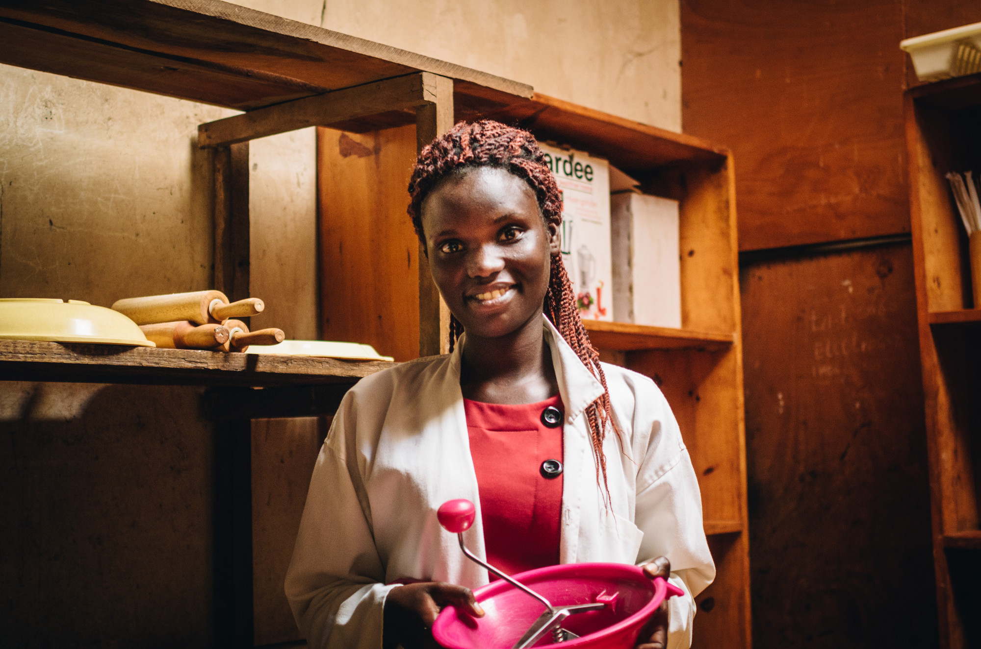 A Rwandan woman holding a pink bowl