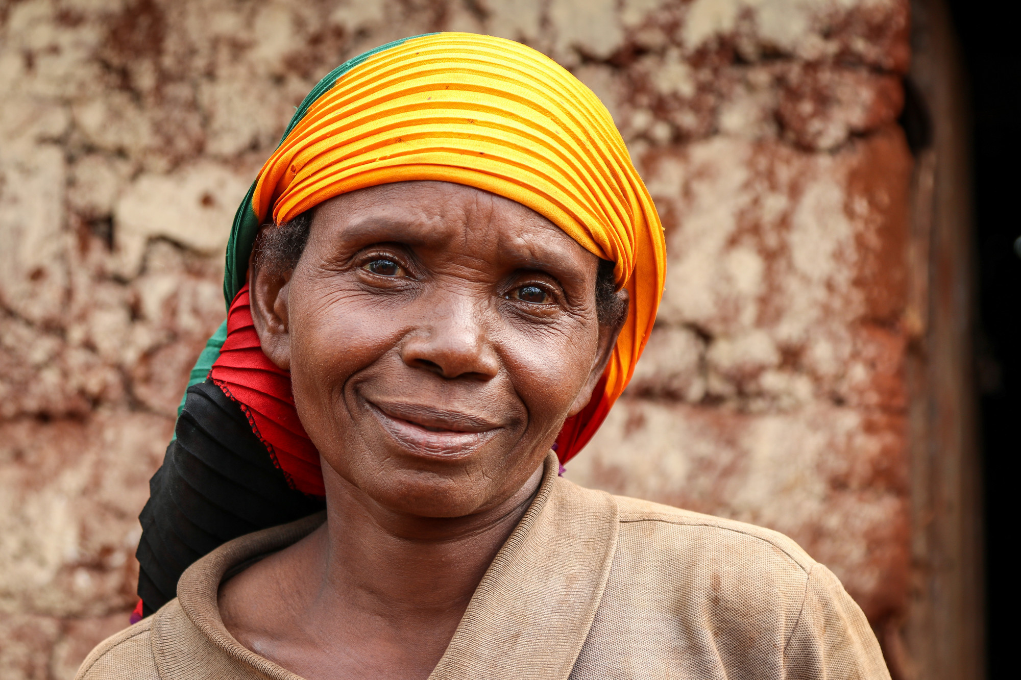 A portrait of a Burundi woman with a colorful scarf around her head