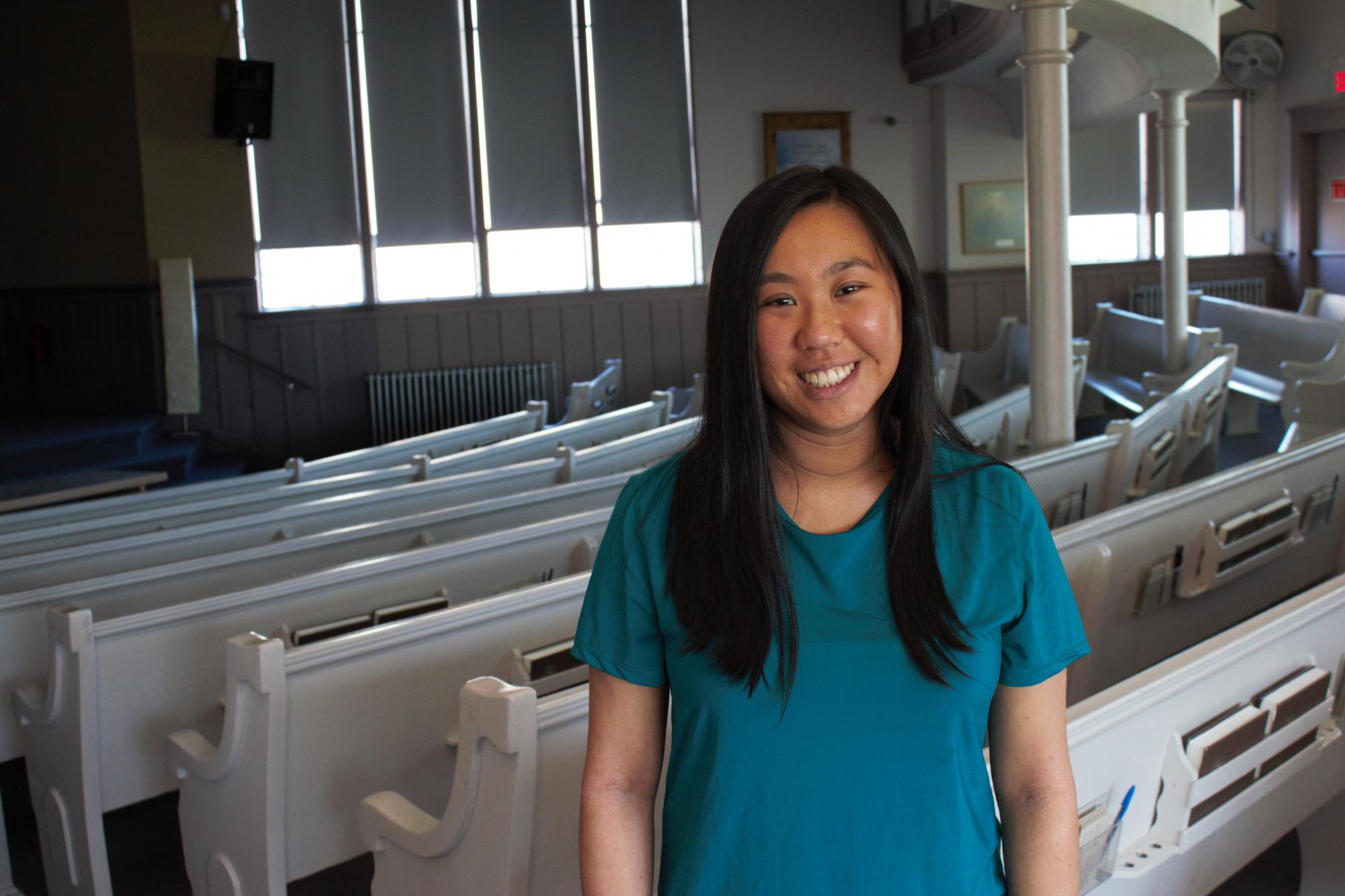 A young woman stands in a church sanctuary