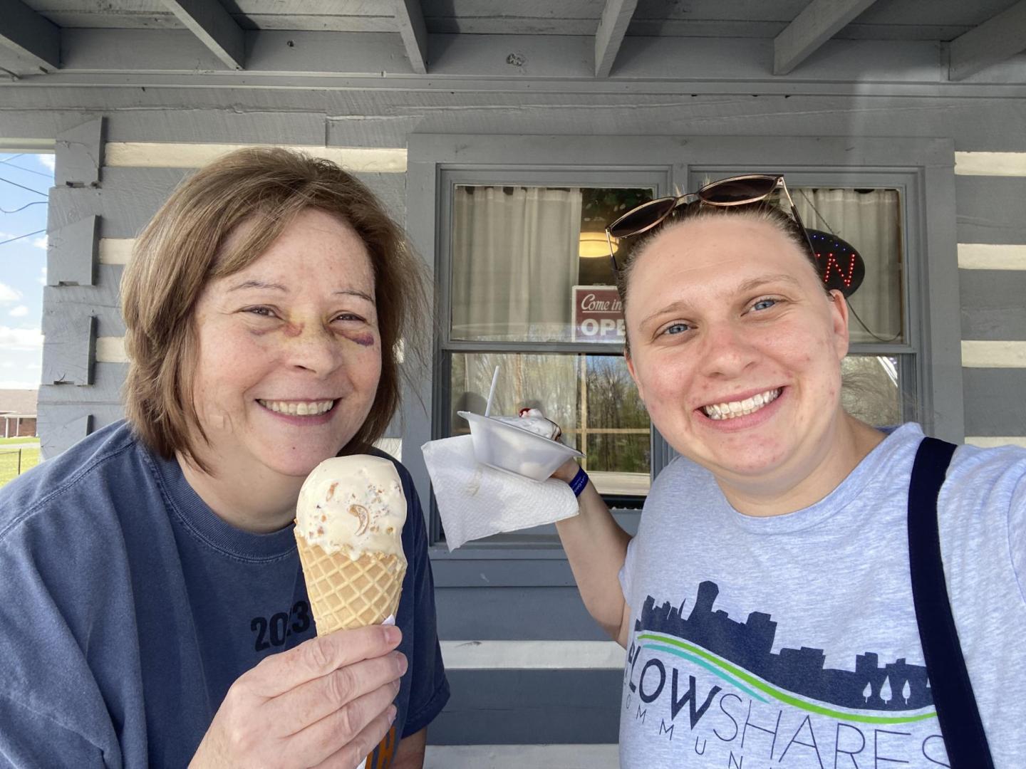 Two women take a selfie together. They are both holding ice cream