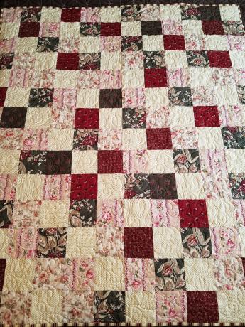 A quilt with red, white and pink squares