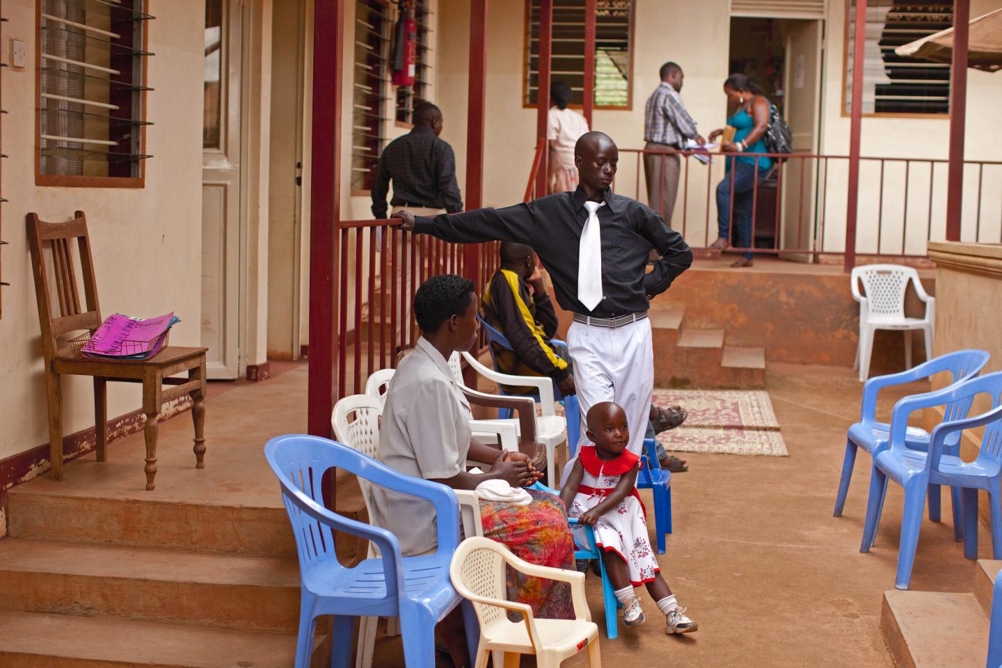 People wait outside a clinic in Uganda