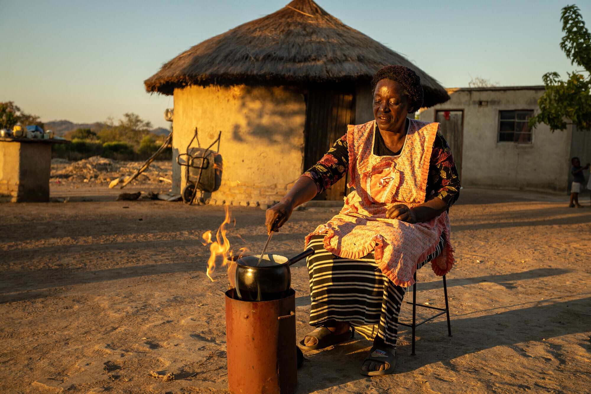 A woman cooking outside of her home in Zimbabwe