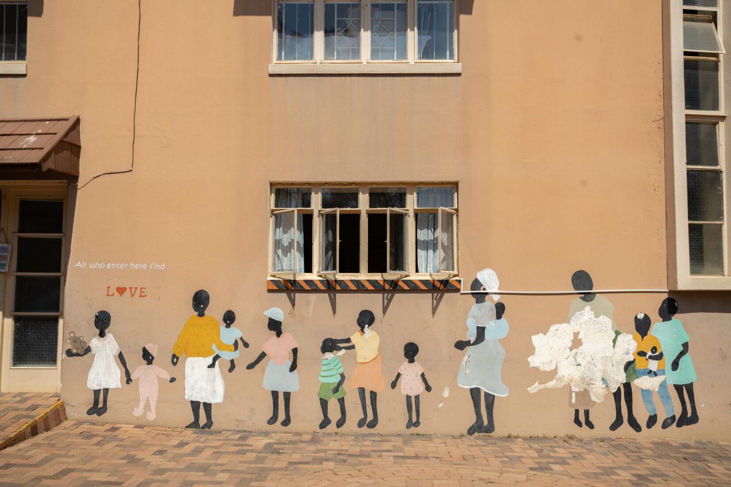 A building in Zimbabwe with a mural of people painted on the side of it