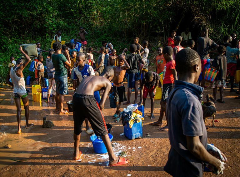 A crop of people collecting water