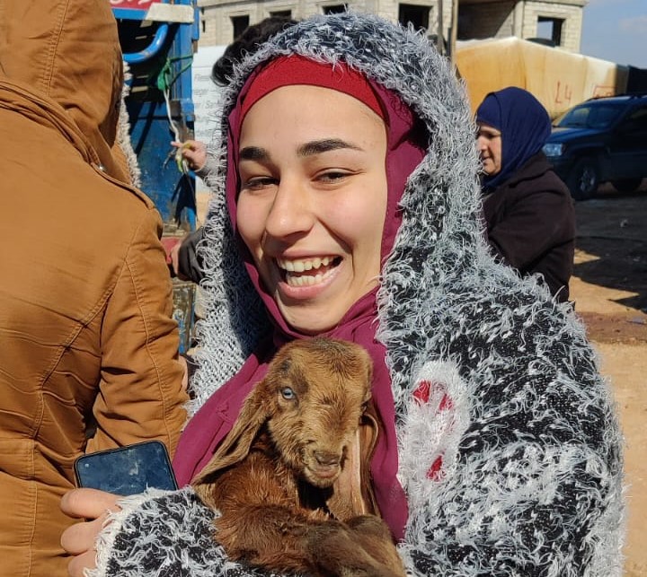 A woman holding a goat