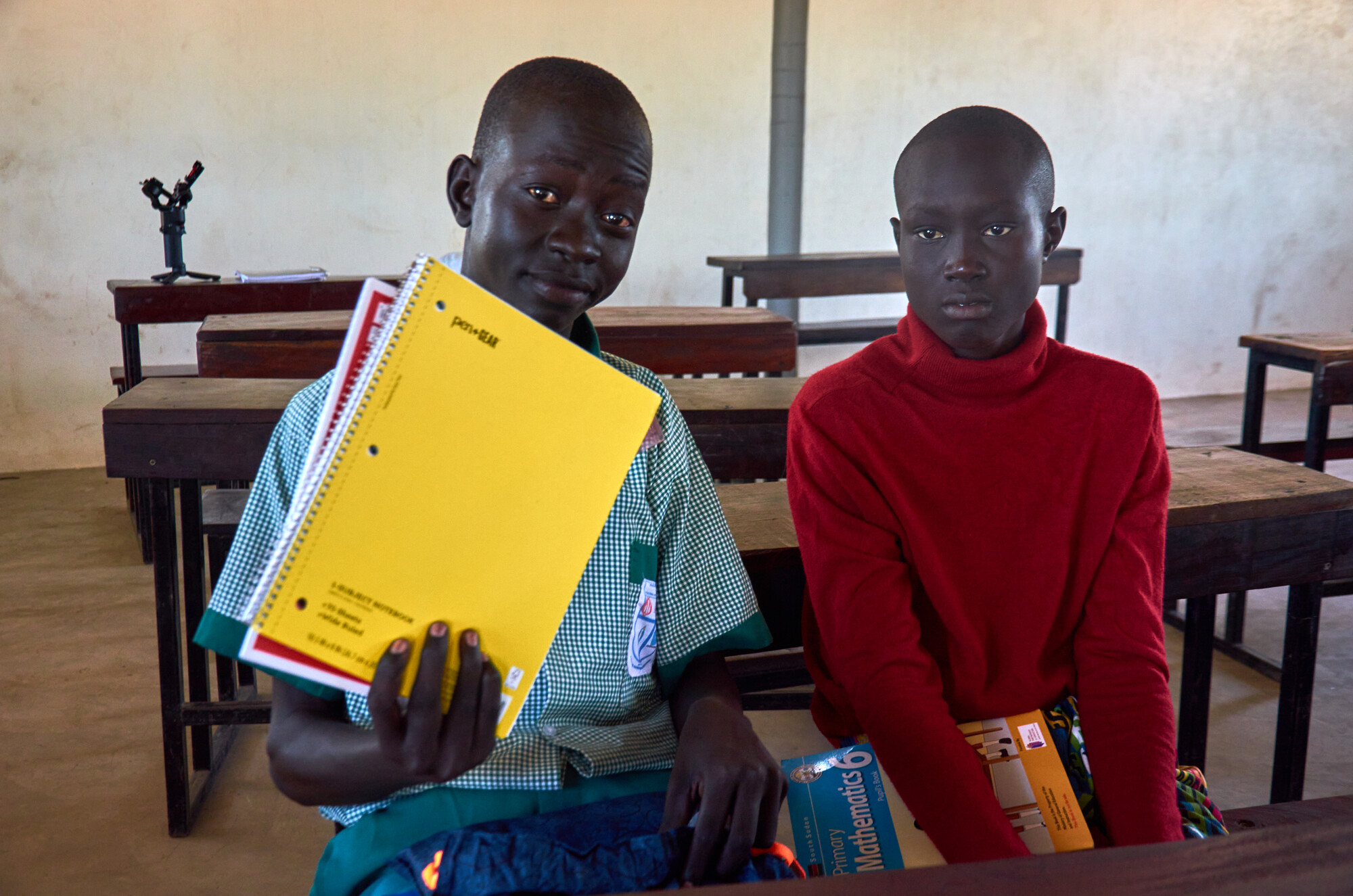 Peter Thon Mathiang, left, with Ruaidit Majak Dierkuei , both students at at Saint Mary’s Primary School, Thon-Aduel, holds the contents of his school kit.