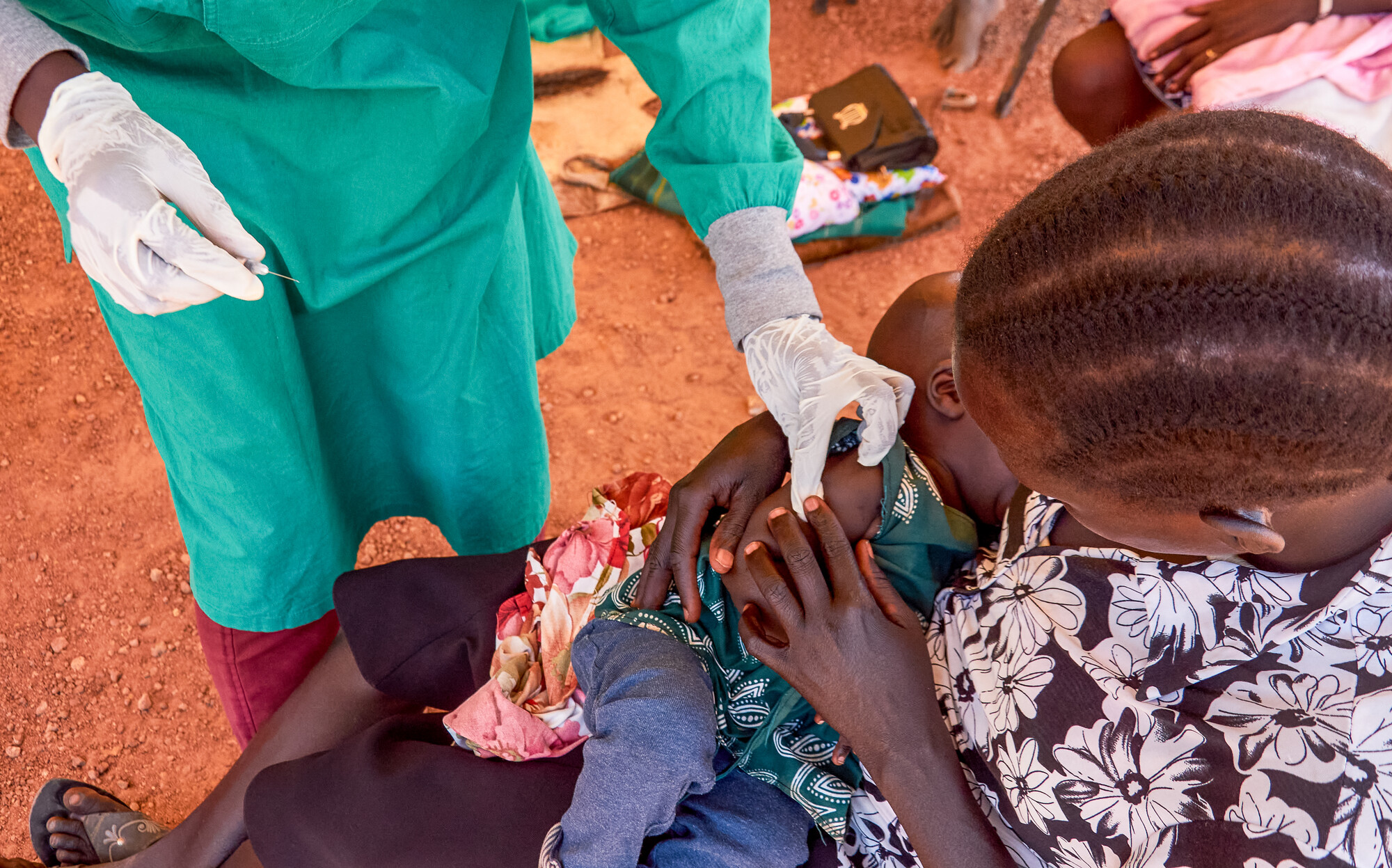 A woman holding an infant receiving a vaccine