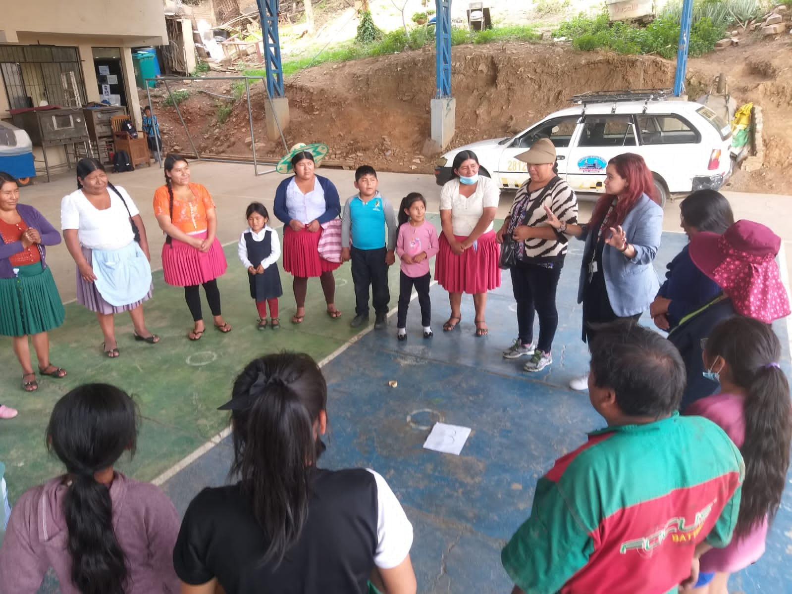 A young woman speaks to group of adults and children outside