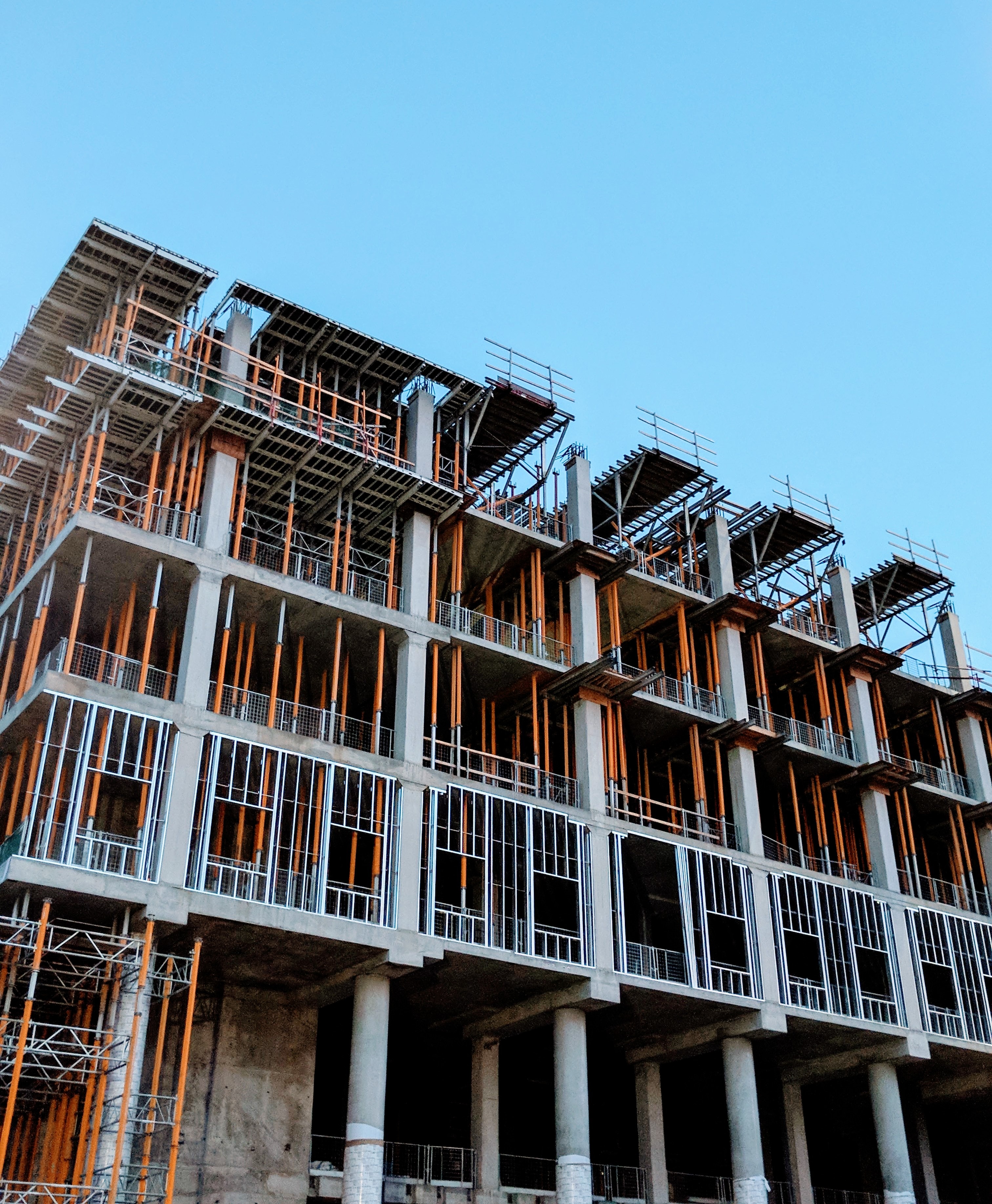 Apartment building under construction with exposed steel beams and concrete