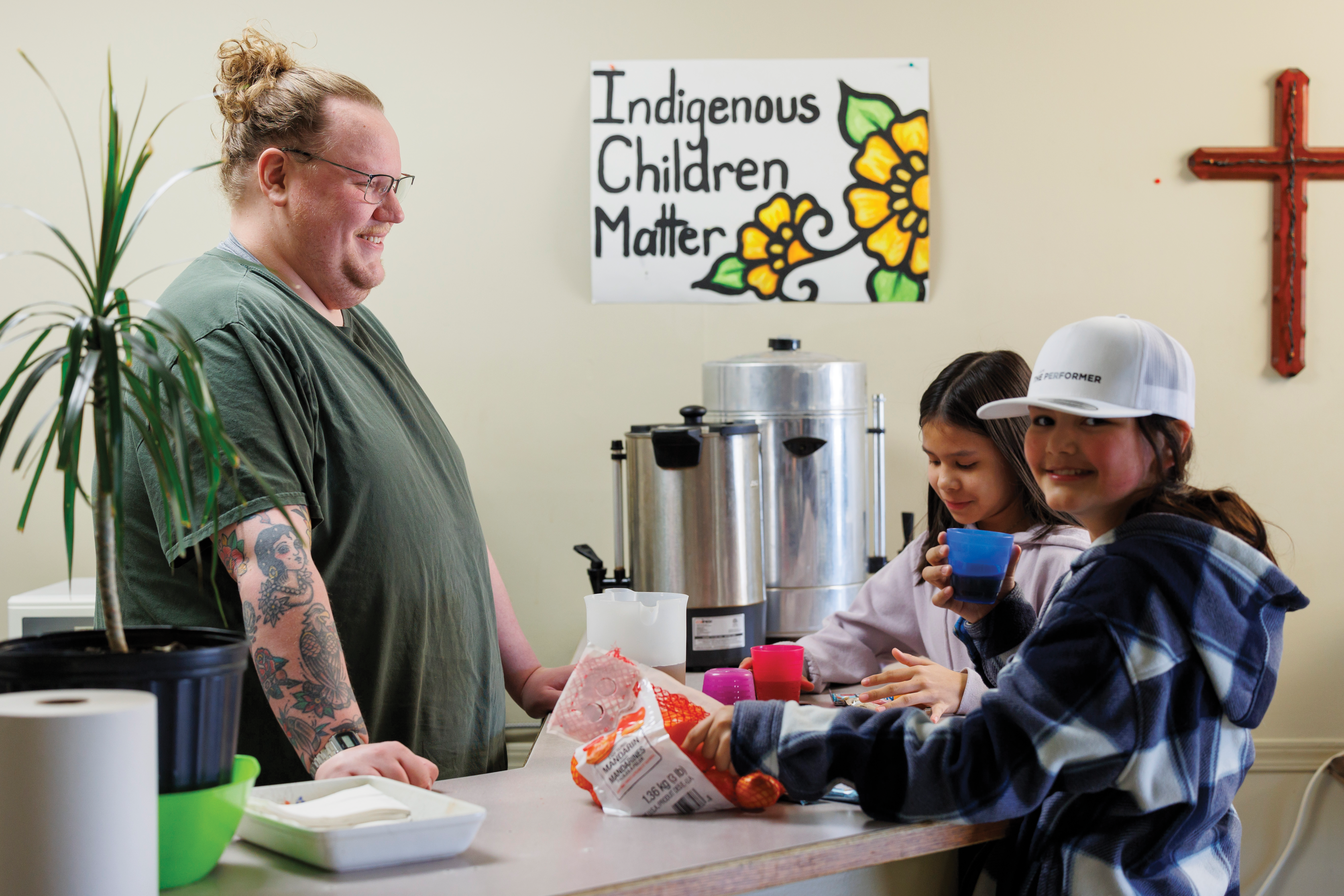 A man serving food to two young girls