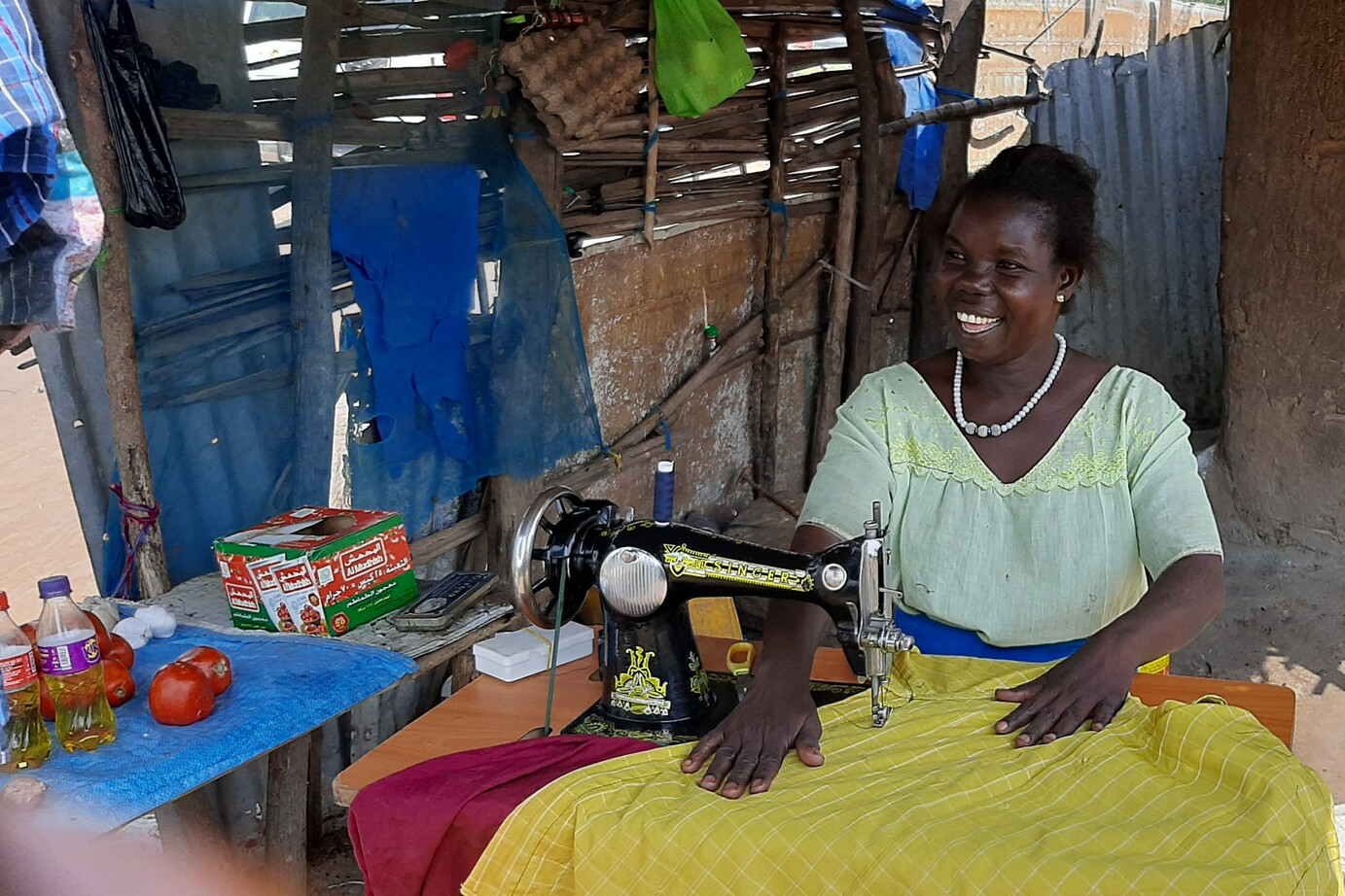 A woman working on brightly colored fabric with a sewing machine