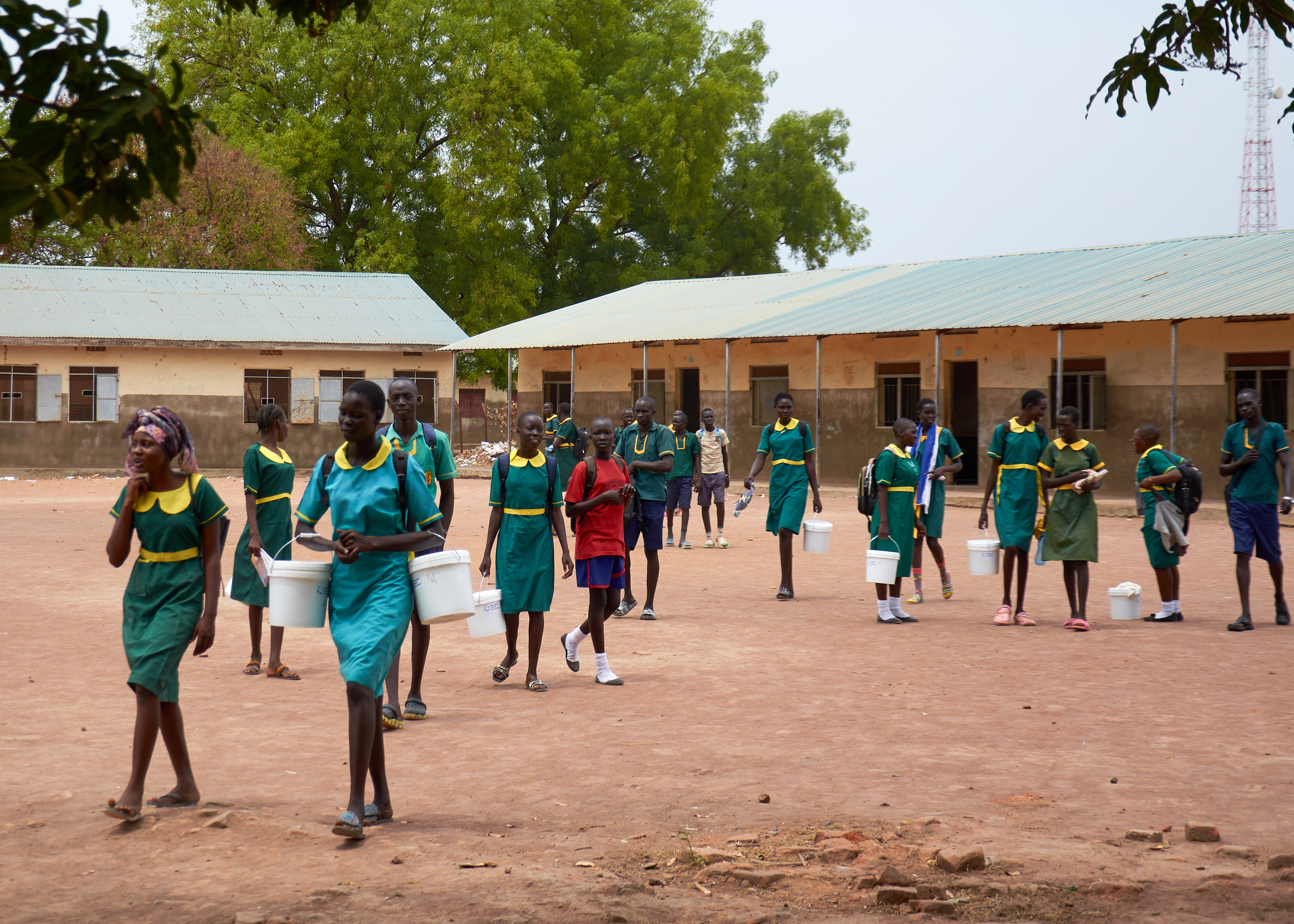 Picture of students at Rumbek Comboni Primary School in South Sudan carry their dignity kits which were provided by MCC.
