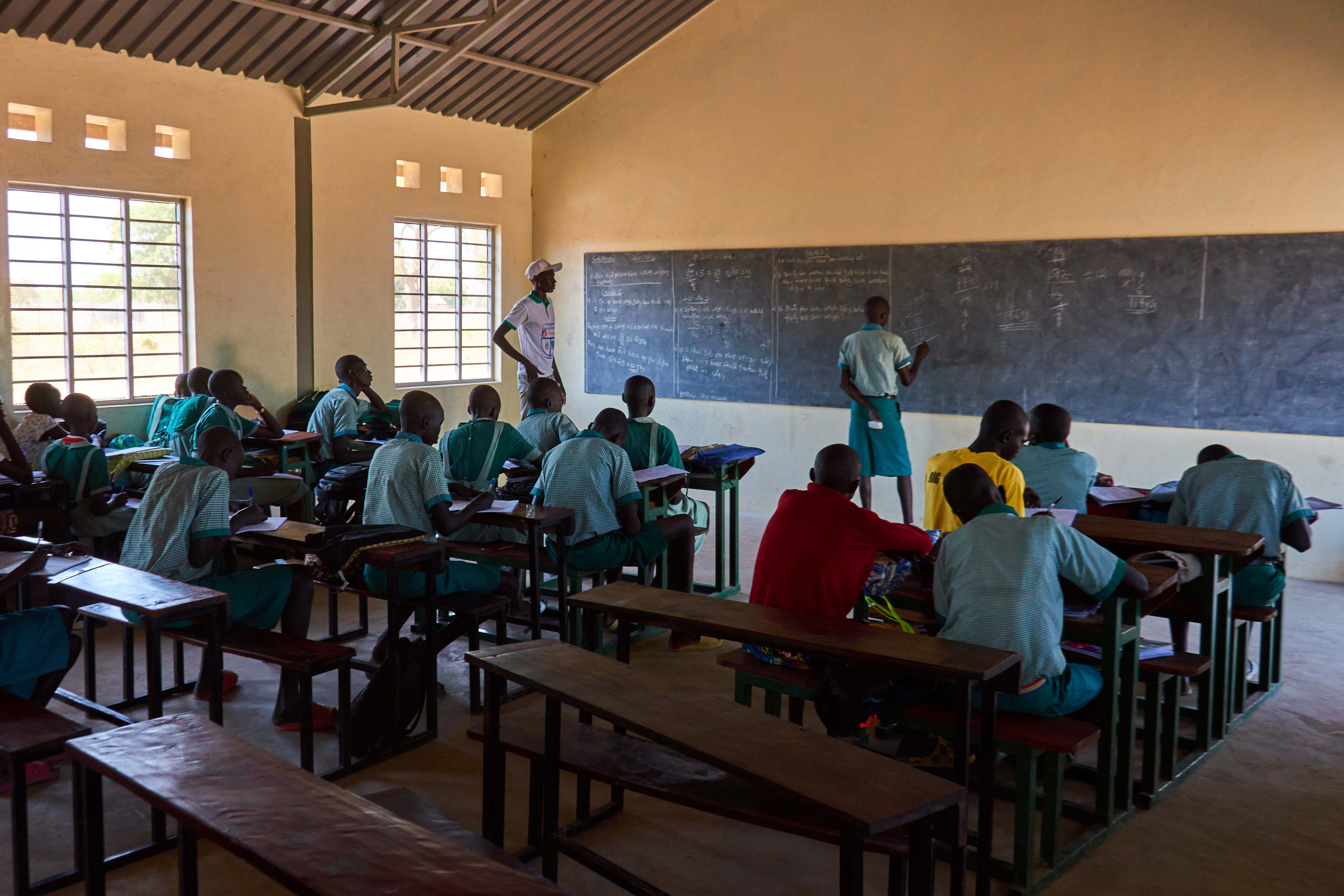 Peter Aru Mayek, 23, solving a sum on the class chalkboard at Saint Mary’s Primary School, Thon-Aduel.