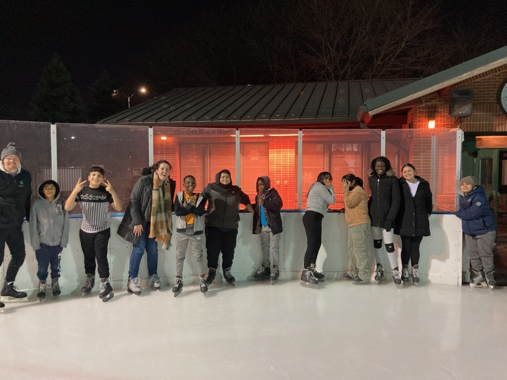 Charles, third from right, ice skates with the staff and children from Living Works’ after-school program.