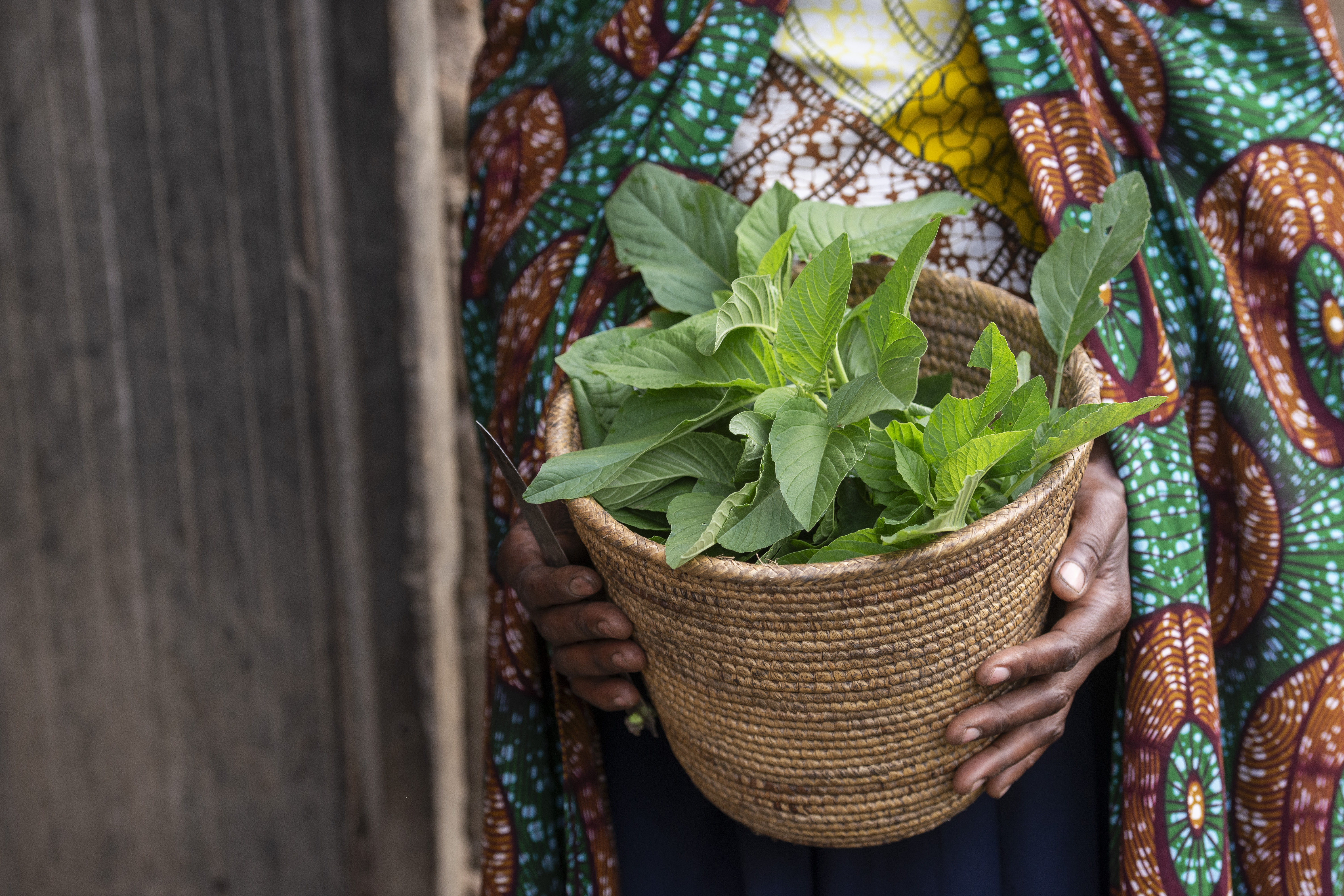 a woman holding a pot with her latest crop
