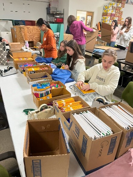 youth packing school supplies in bags