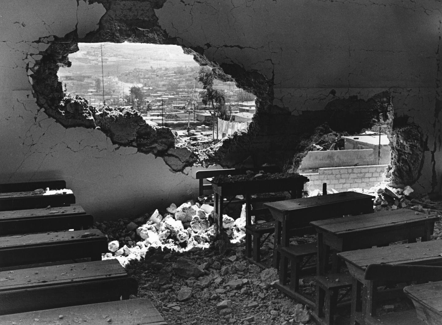 A black and white photo of a damaged wall in Palestine
