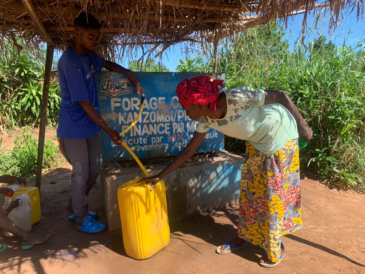 Marie Jeanne Kudimuka fills up her water jug with clean water drawn from a recently built borehole in Kikwit.