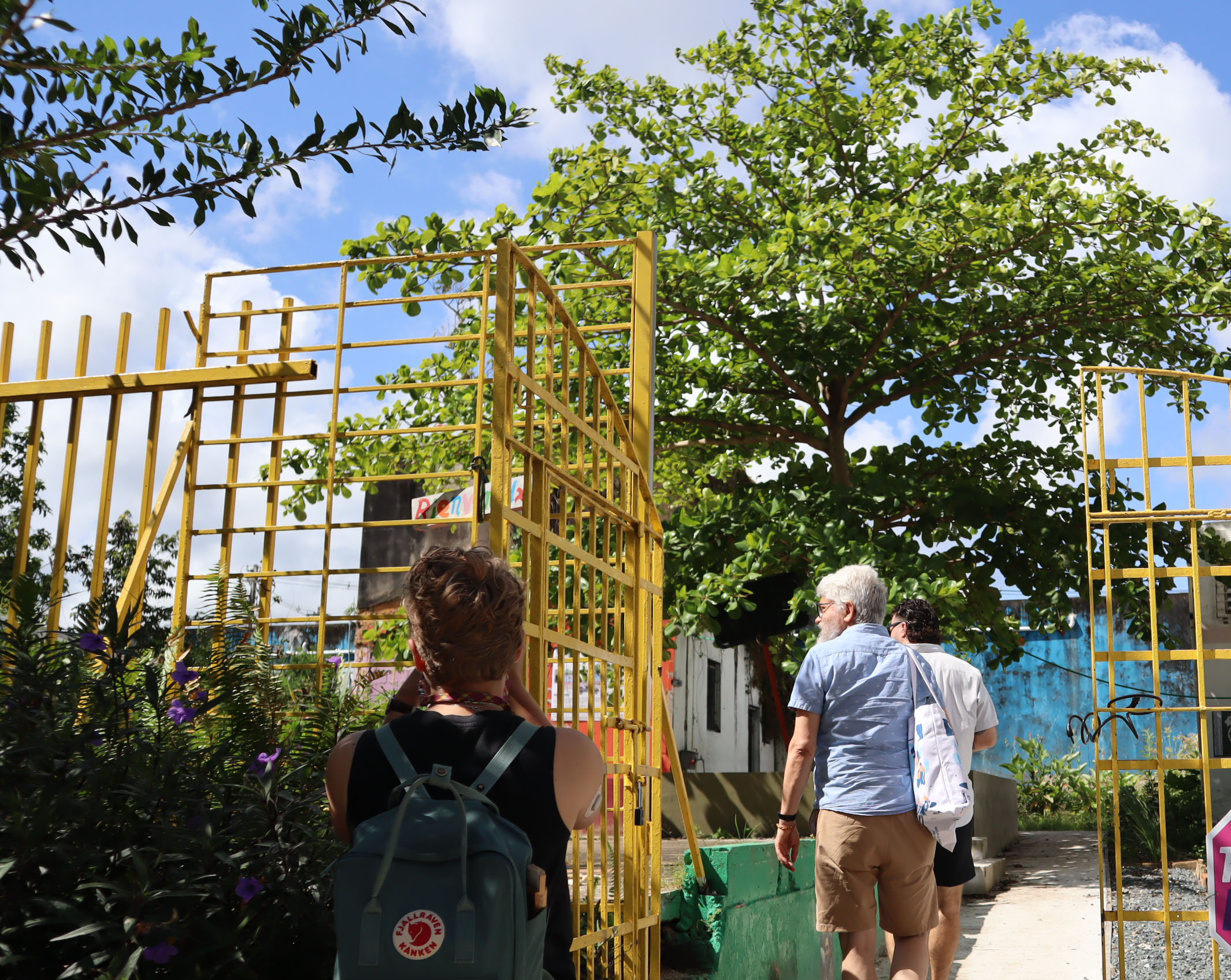 MCC and Anabaptist Climate Collaborative staff walk into Huerto Feliz, a community garden project by Urbe Apie in Caguas, Puerto Rico