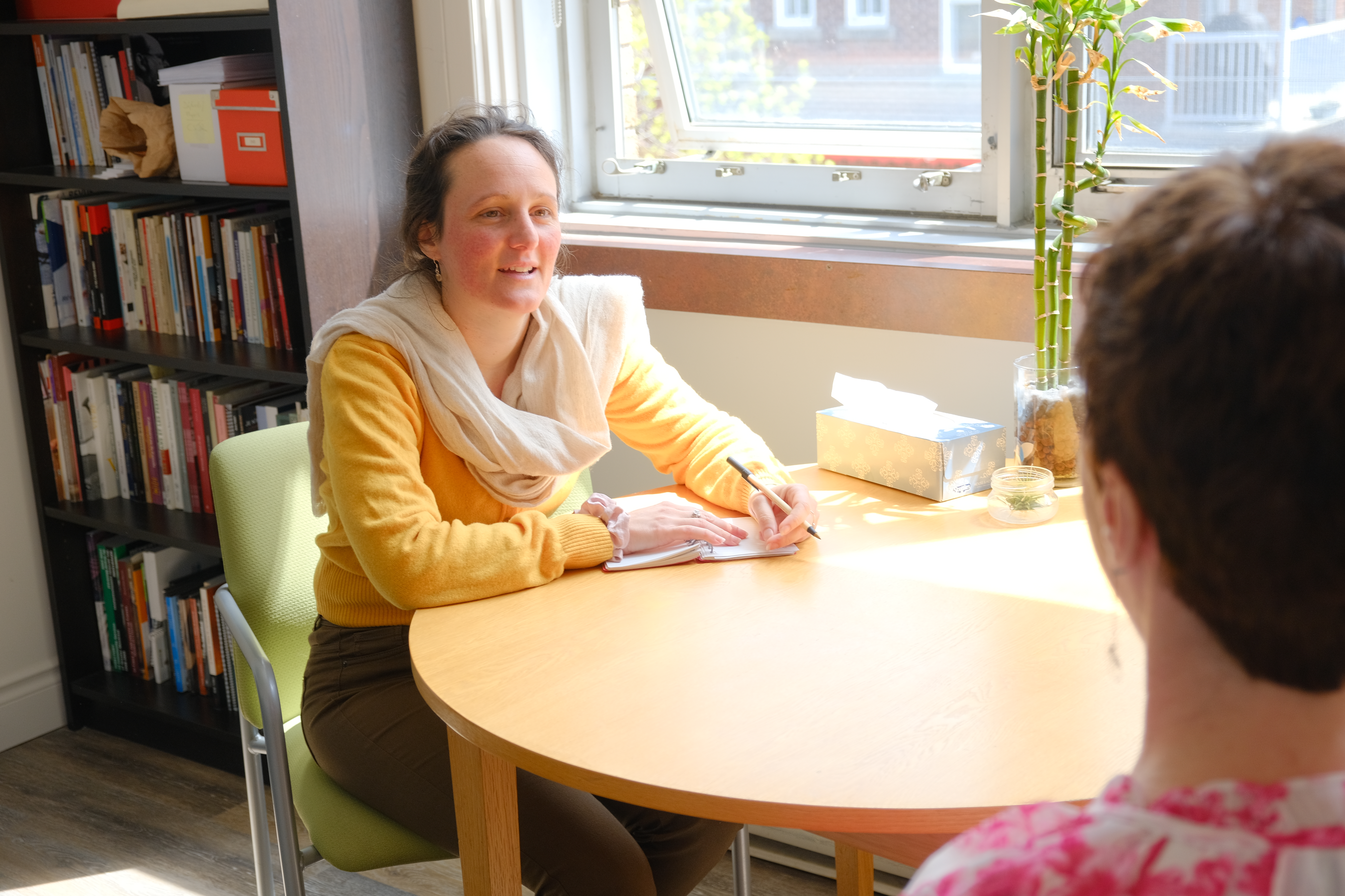 Two women sit at a table in conversation