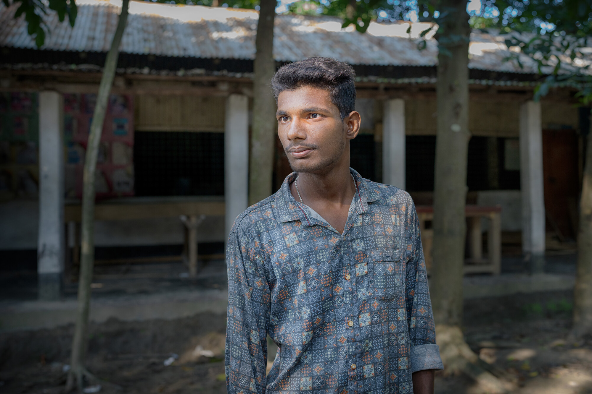 A person stands center frame looking off camera.