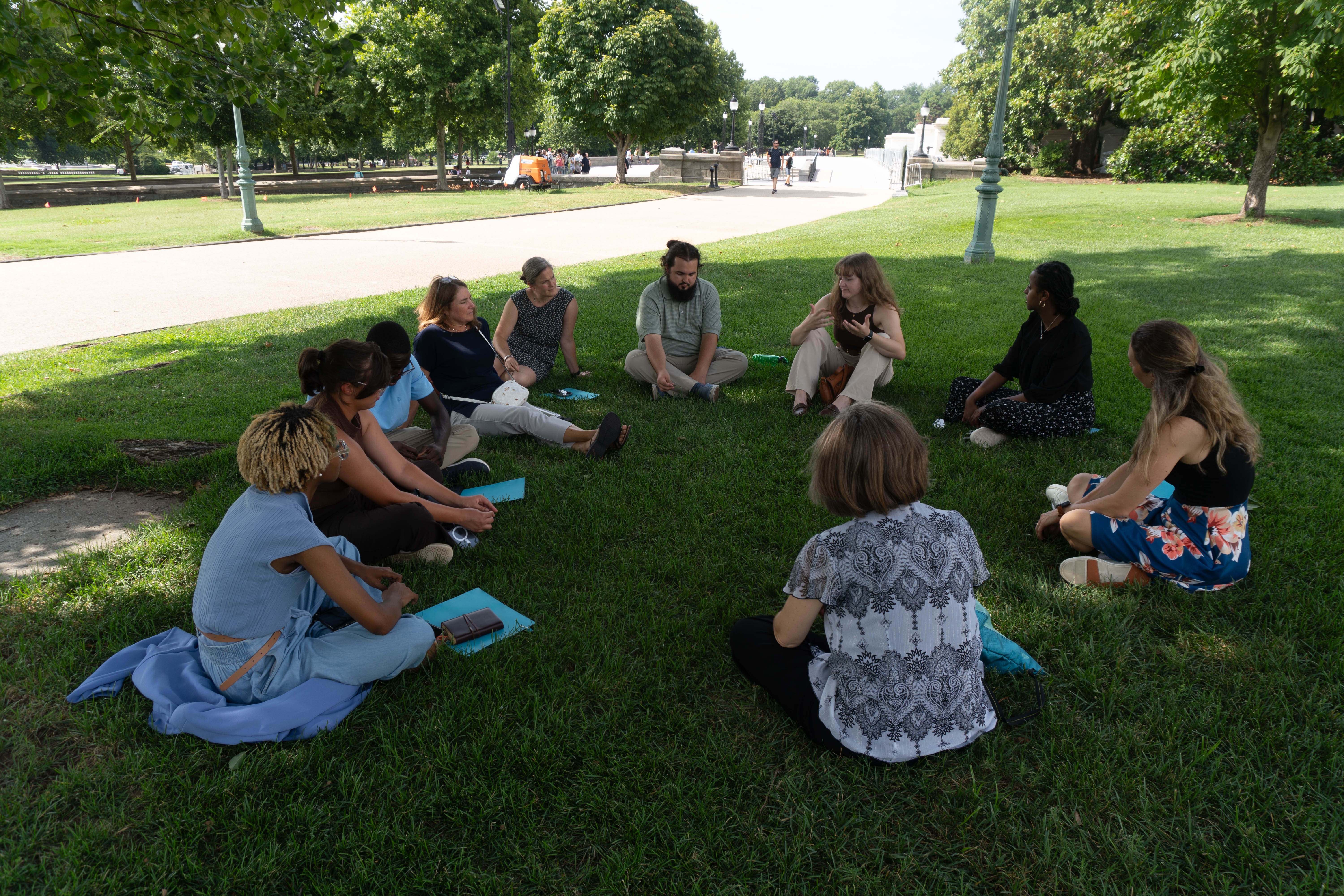 Students sit in a circle in the grass