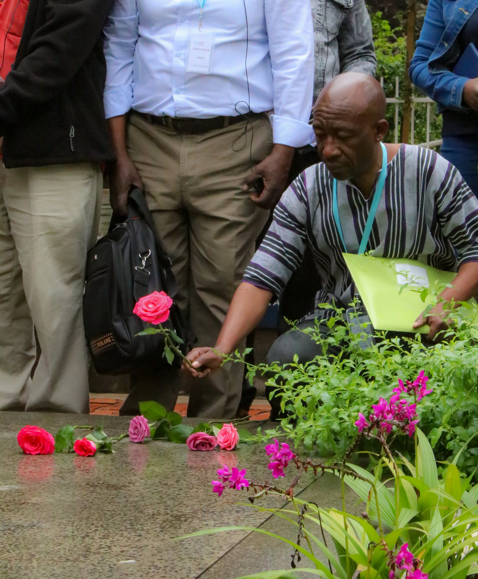 man placing rose on the ground