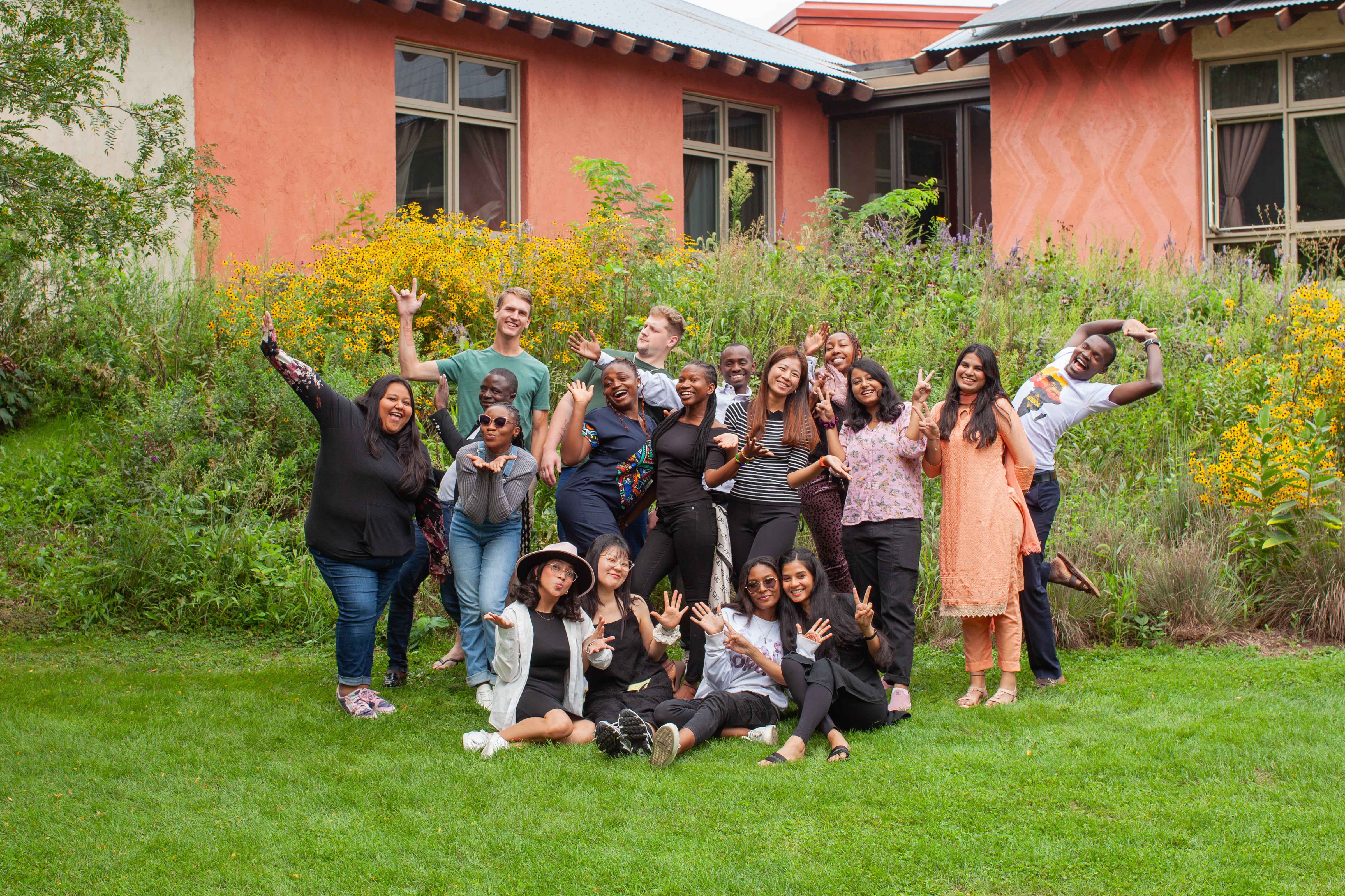 A group of 17 young adults strike various poses together.