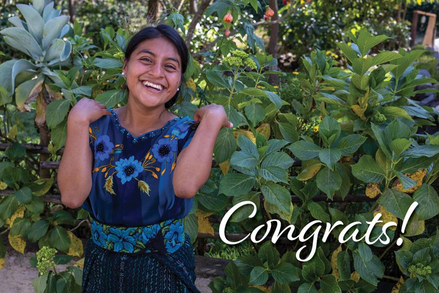 A smiling woman standing with the word "Congrats!"