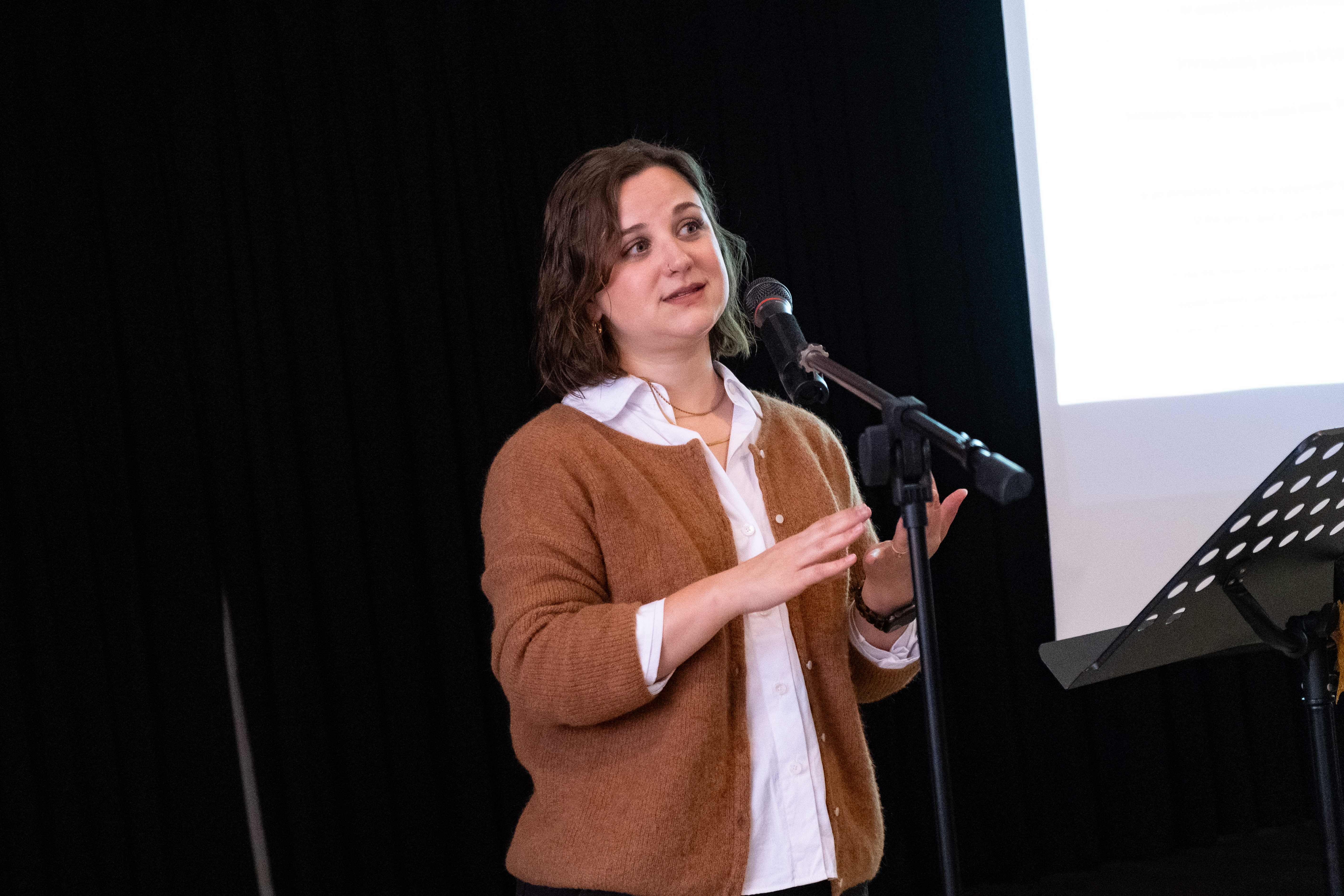 Sarah Funkhouser speaking at into a microphone in a church in Montreal.