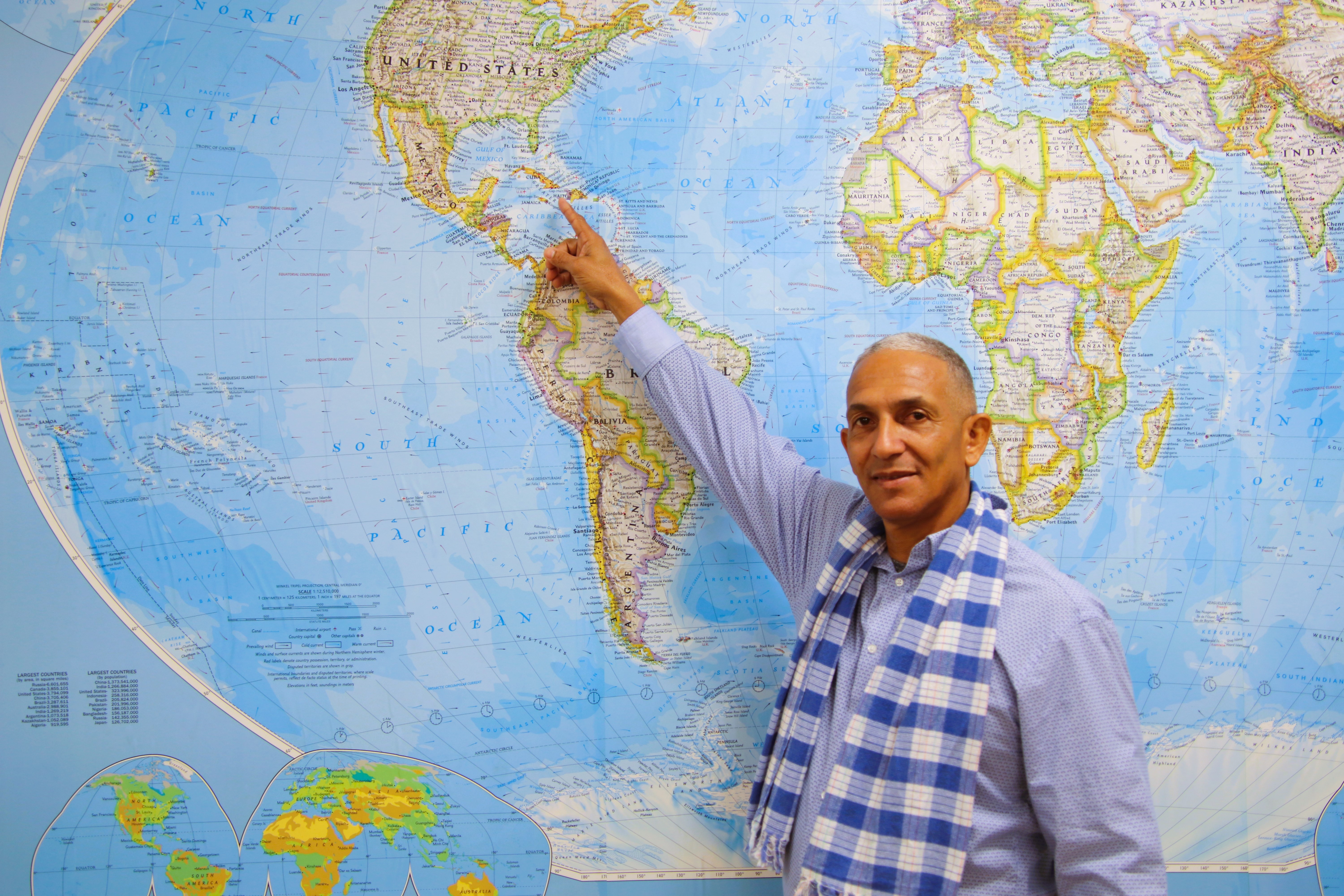 man points at Cuba on a map