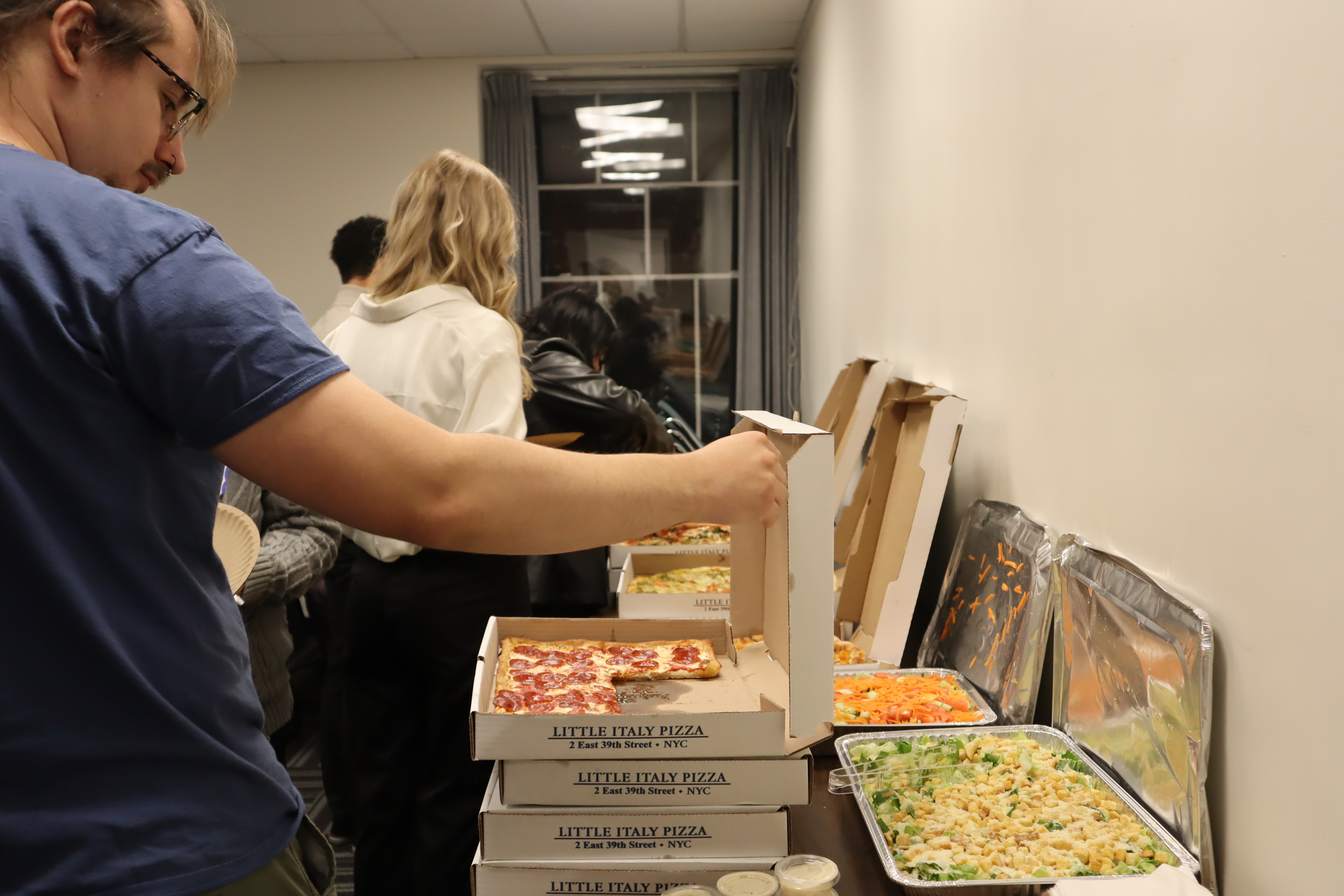 A student grabs New York City pizza during the UN Student Seminar. 