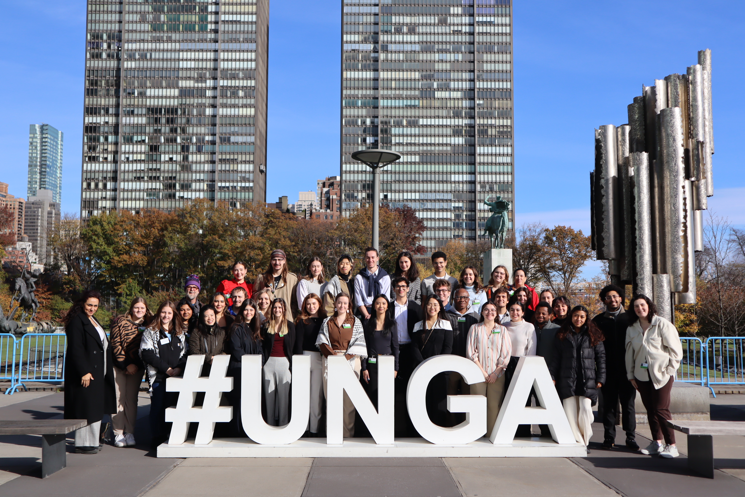 Students gather in front of the United Nations General Assembly sign. 