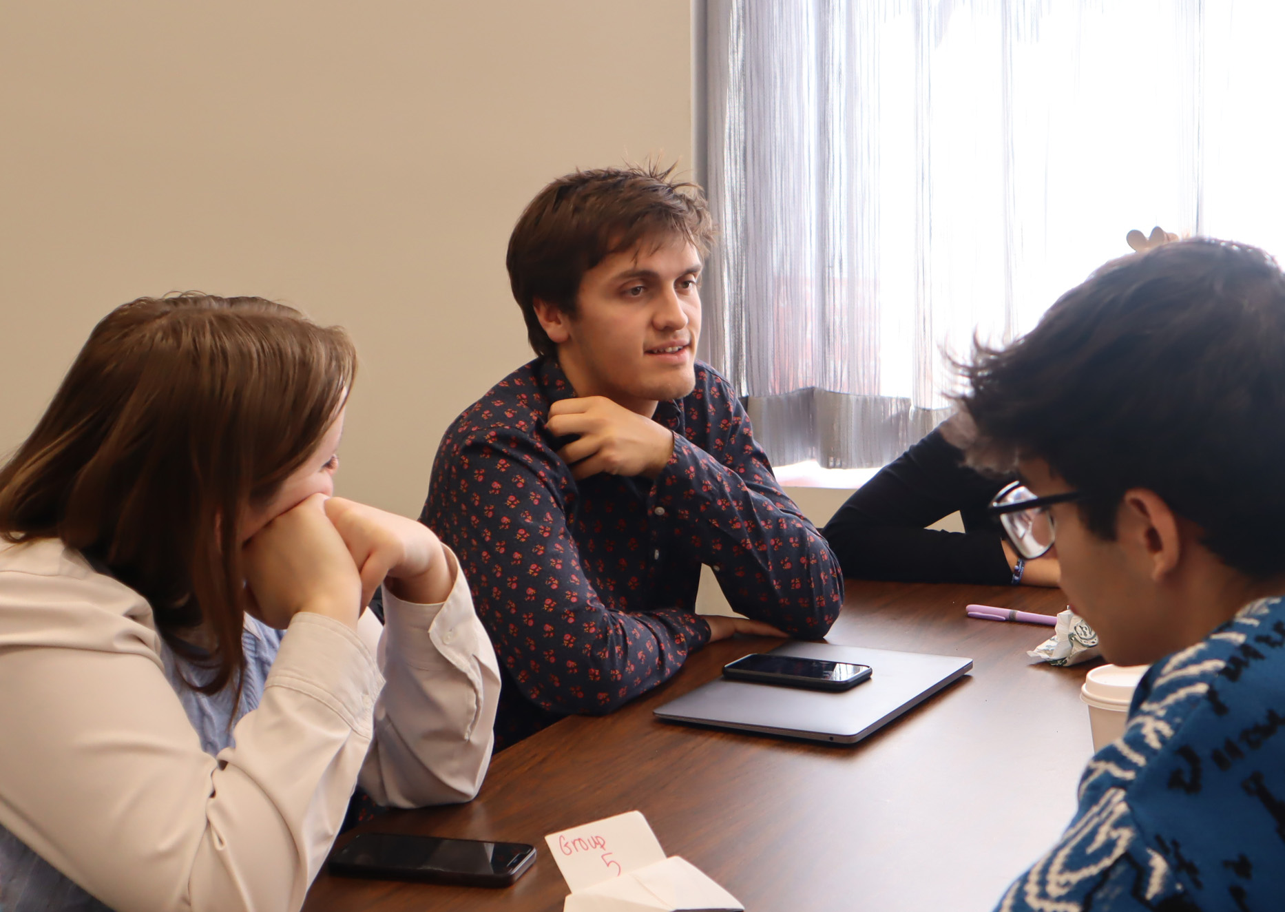 Students sat around a table to engage in a group discussion. 