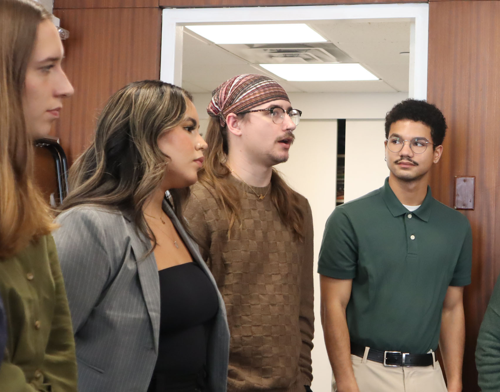 Four students captured standing in a group circle. 