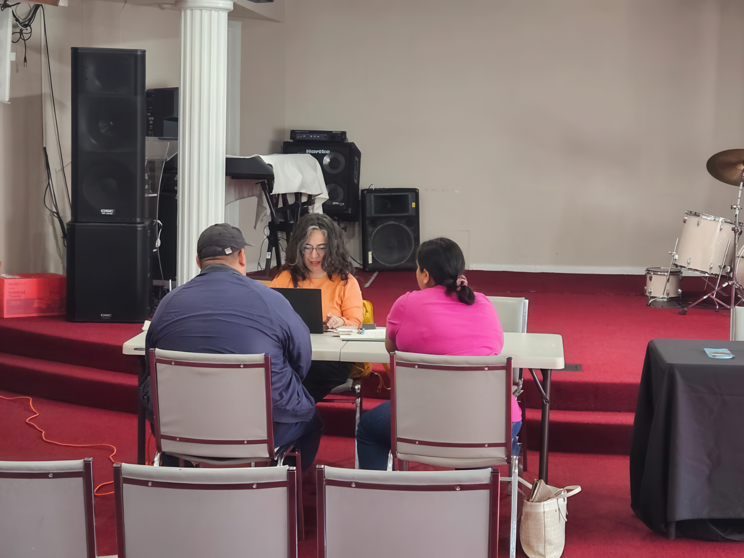 A couple sits at a table talking with a counselor.