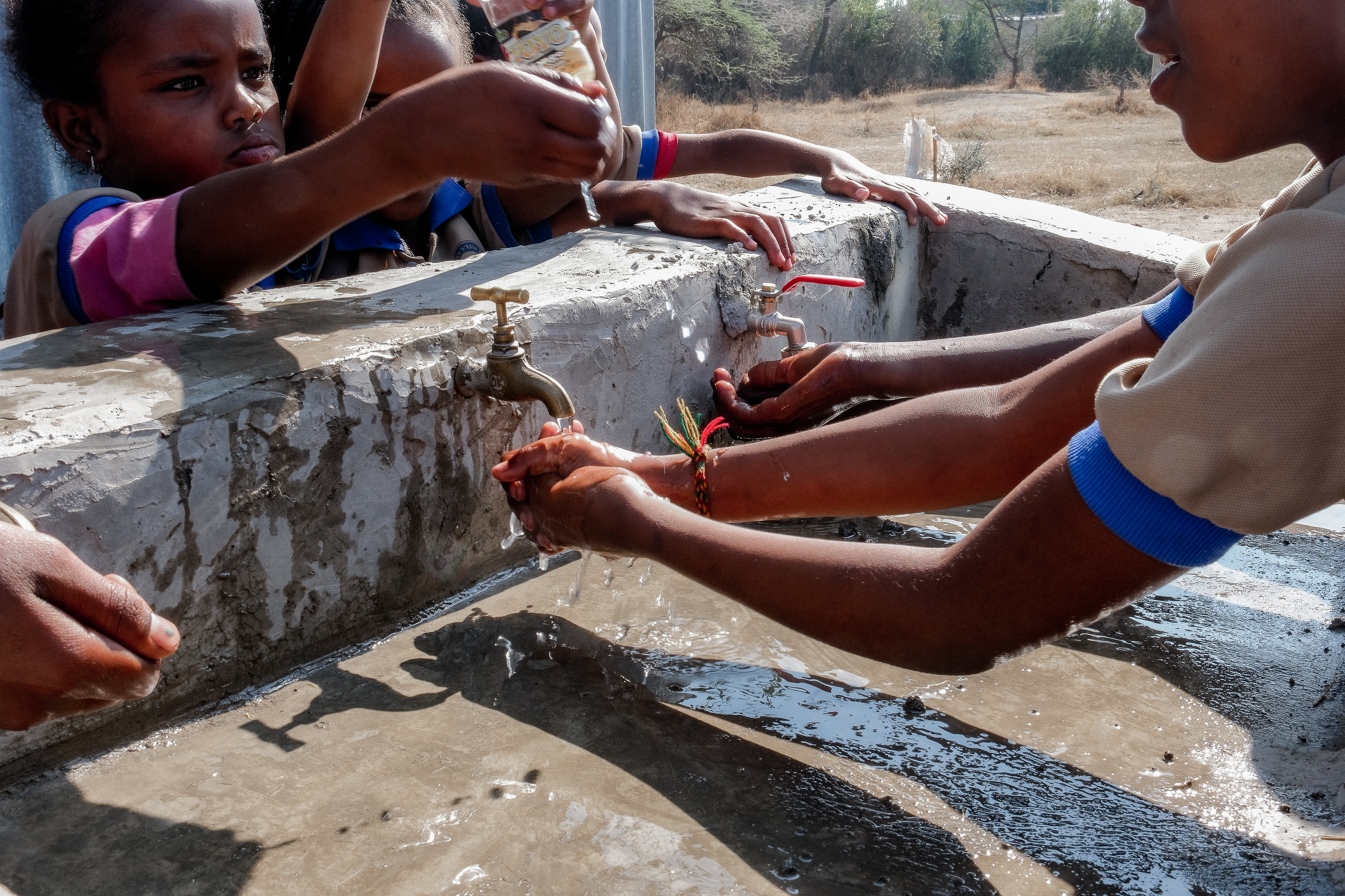 Third grade students enjoy the water taps funded by MCC at Wayu Dembel Primary School in Batu, Ethiopia. March, 2024