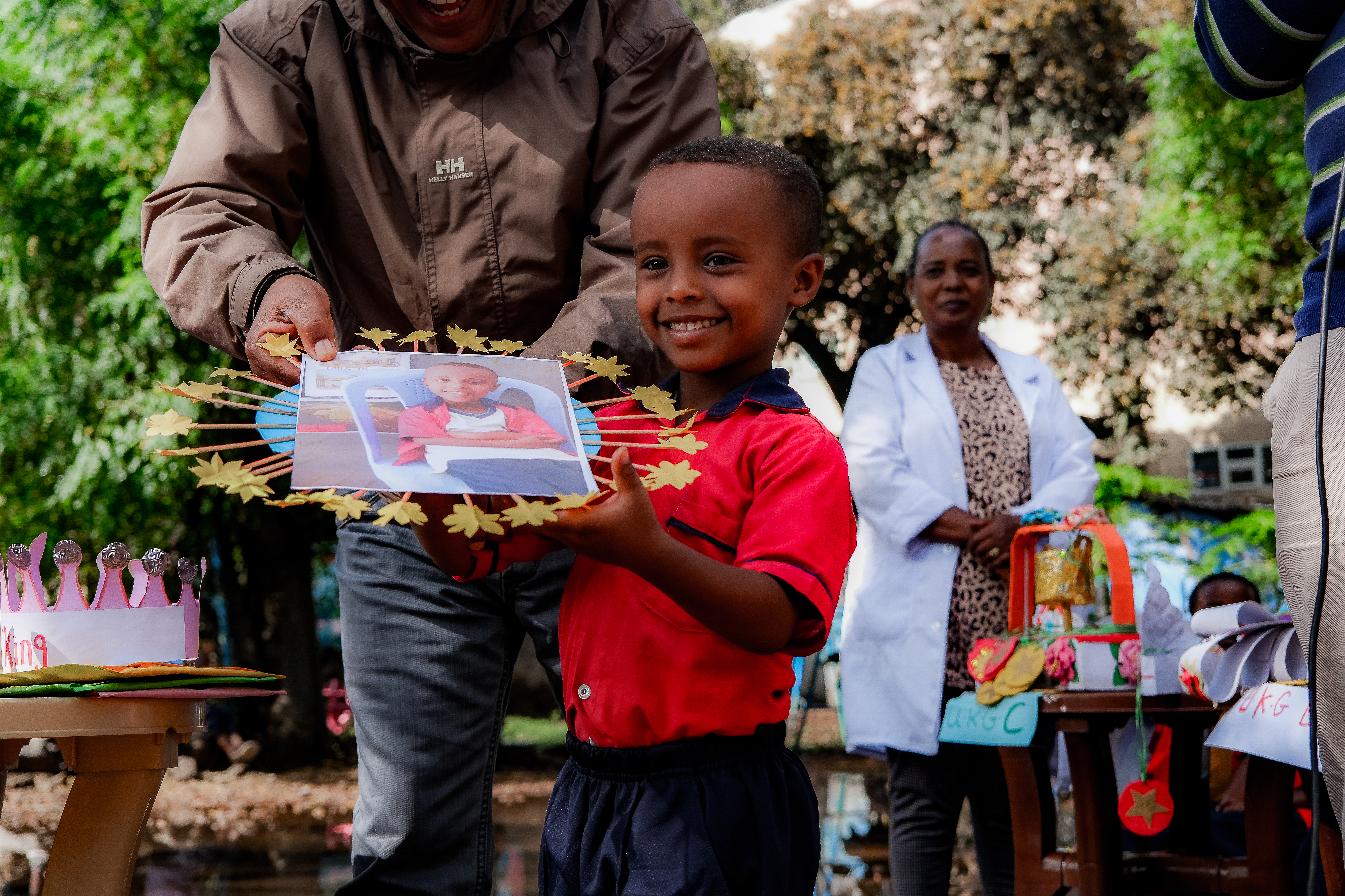 Five-year-old Sudeyis Sherif, collects his award for standing 1st in his nursery school class from MCC staff Solomon along at the morning assembly cermony of RPC Preschool, Adama Ethiopia, March 2024.