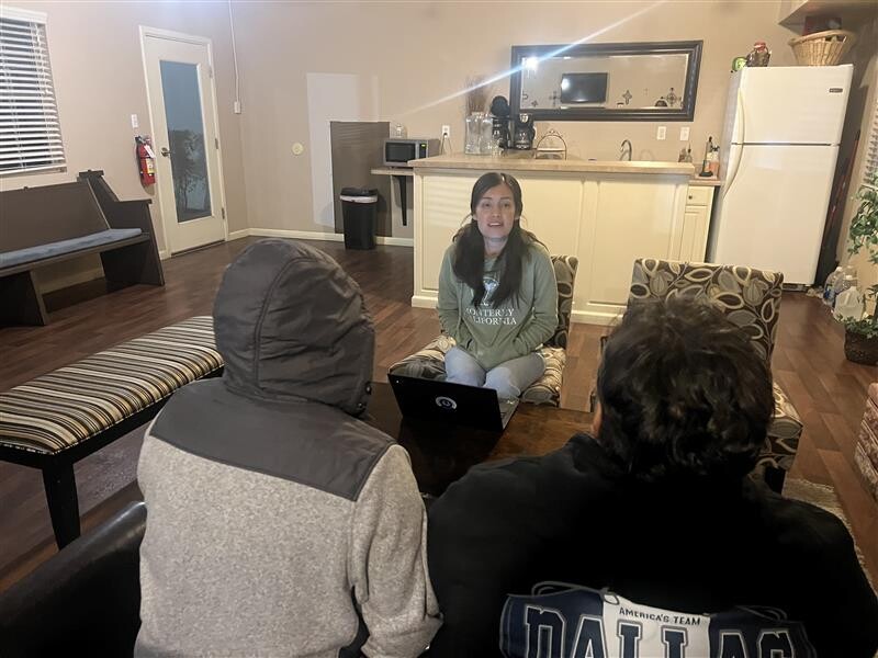 woman facing two people with backs to the camera