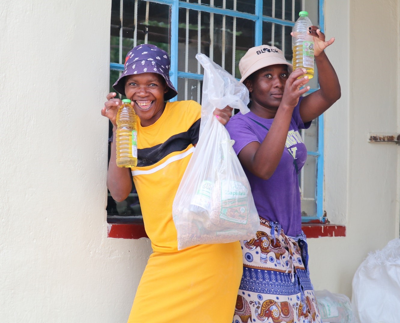 Two women displaying their food items