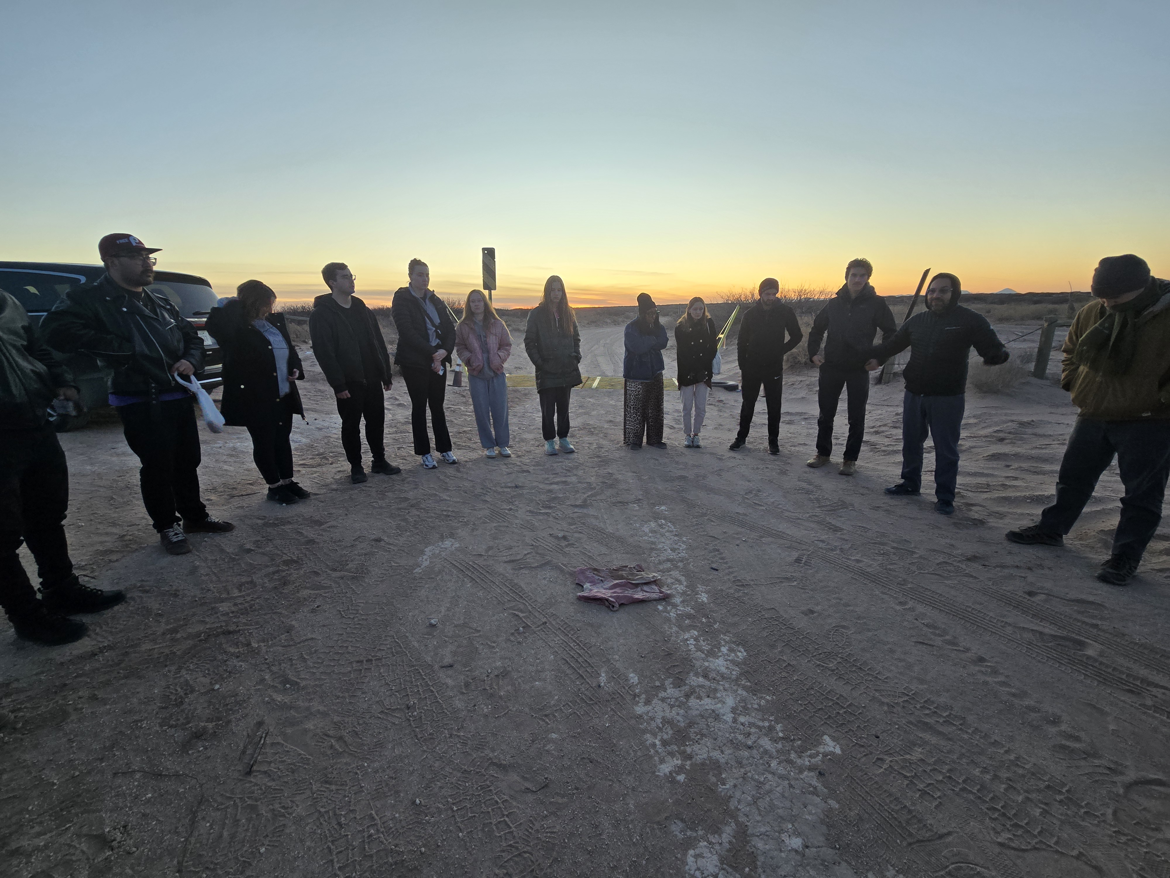 Group of young adults standing in a circle in the desert