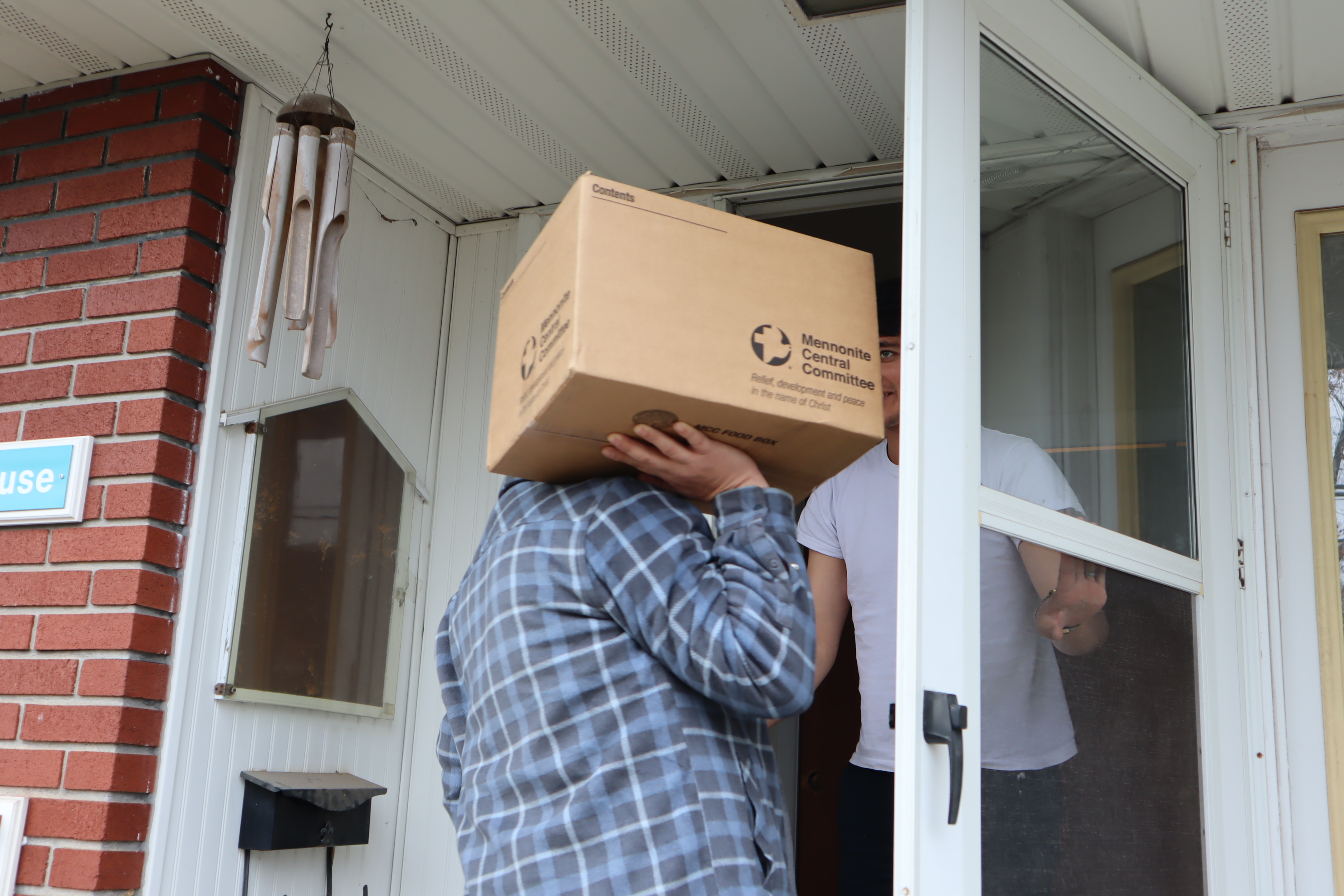 mcc staff delivers a food box to the front door of a house