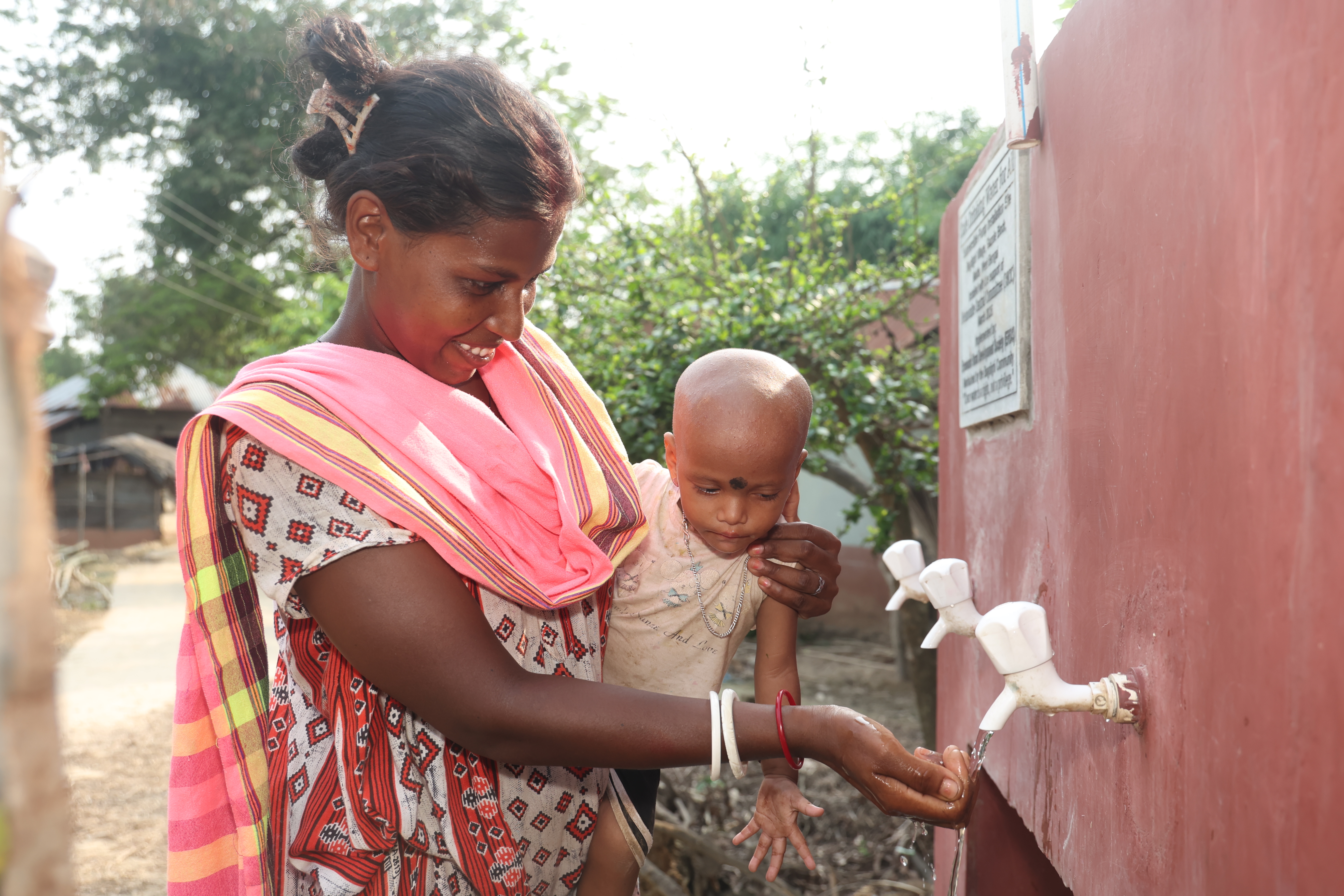 Monju Soren and her friends daughter, Promila (of India) collect clean water from a submersible pump.