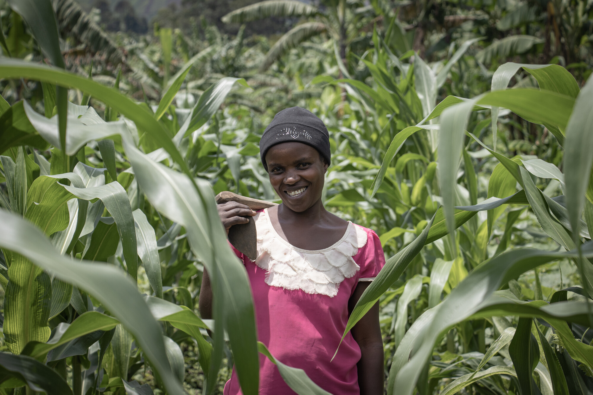 A woman standing in a corn field smiling