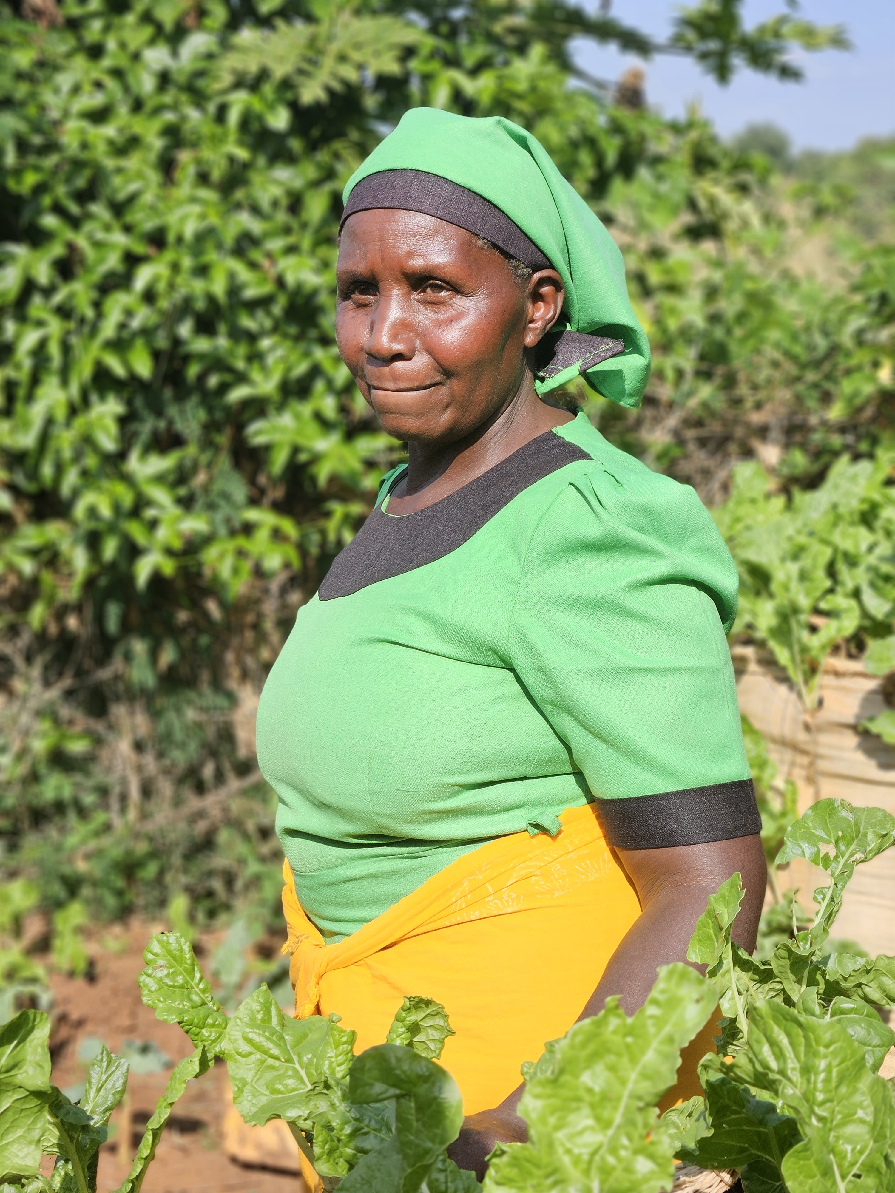 Elizabeth Kimuyu of Kenya stands in her farm where she grows food for her family and to sell in the market.