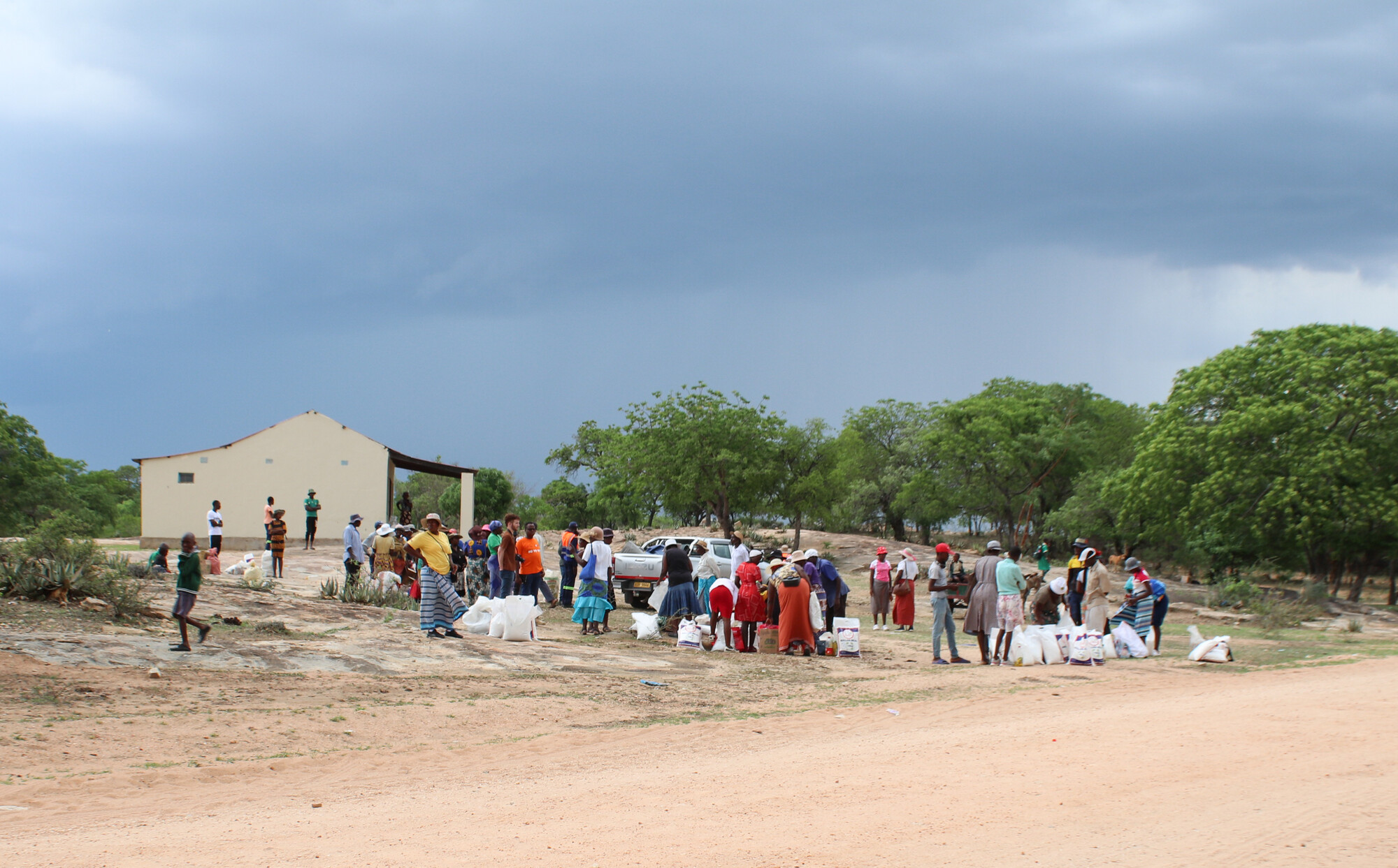 gathering of people in front of buildings with gray sky