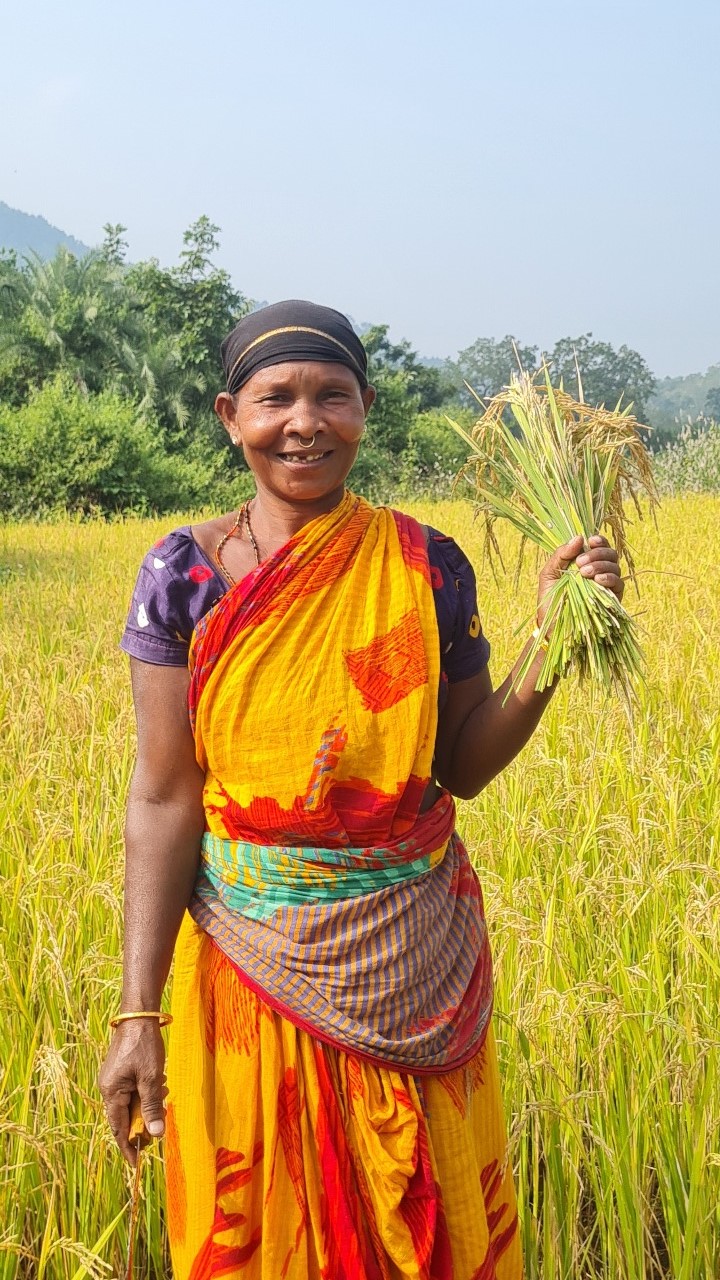 Saramai Mallick of India proudly holds rice that she grew herself to improve her life and her community. 