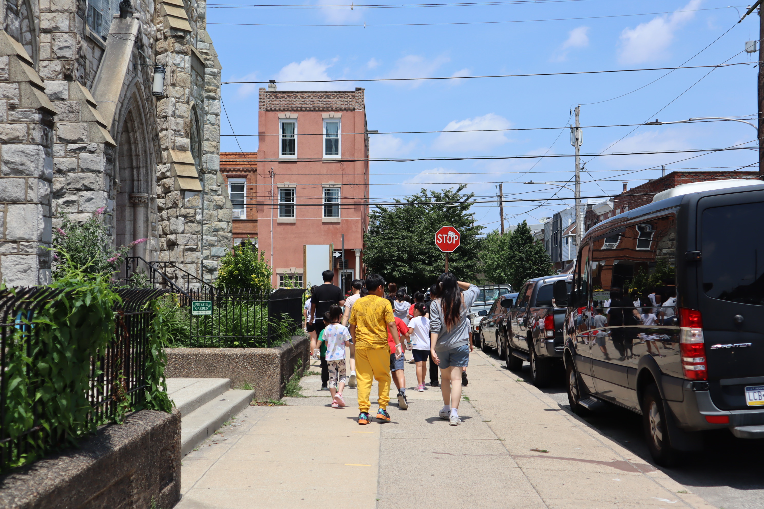 a group of children walk in front of a church in South Philly