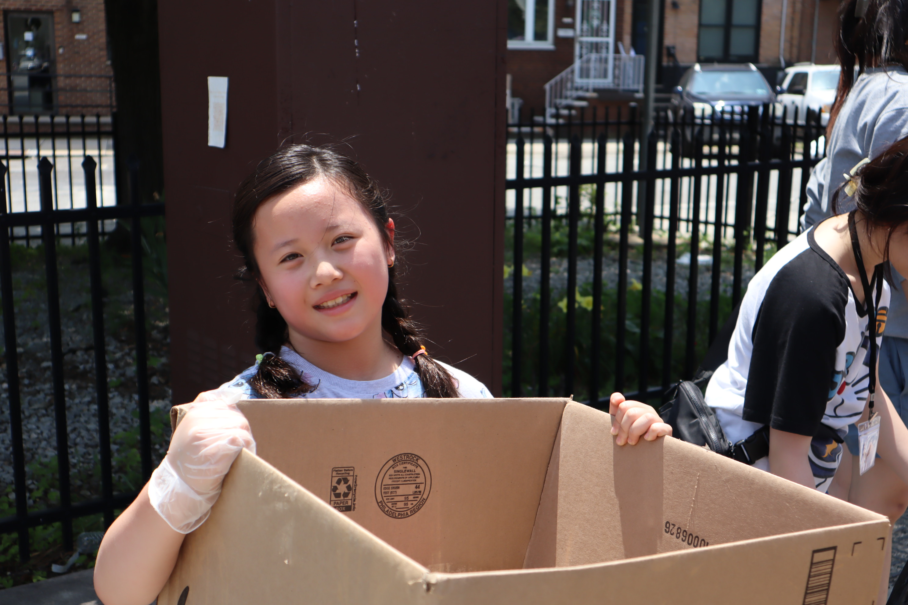 a girl holds a large empty cardboard box
